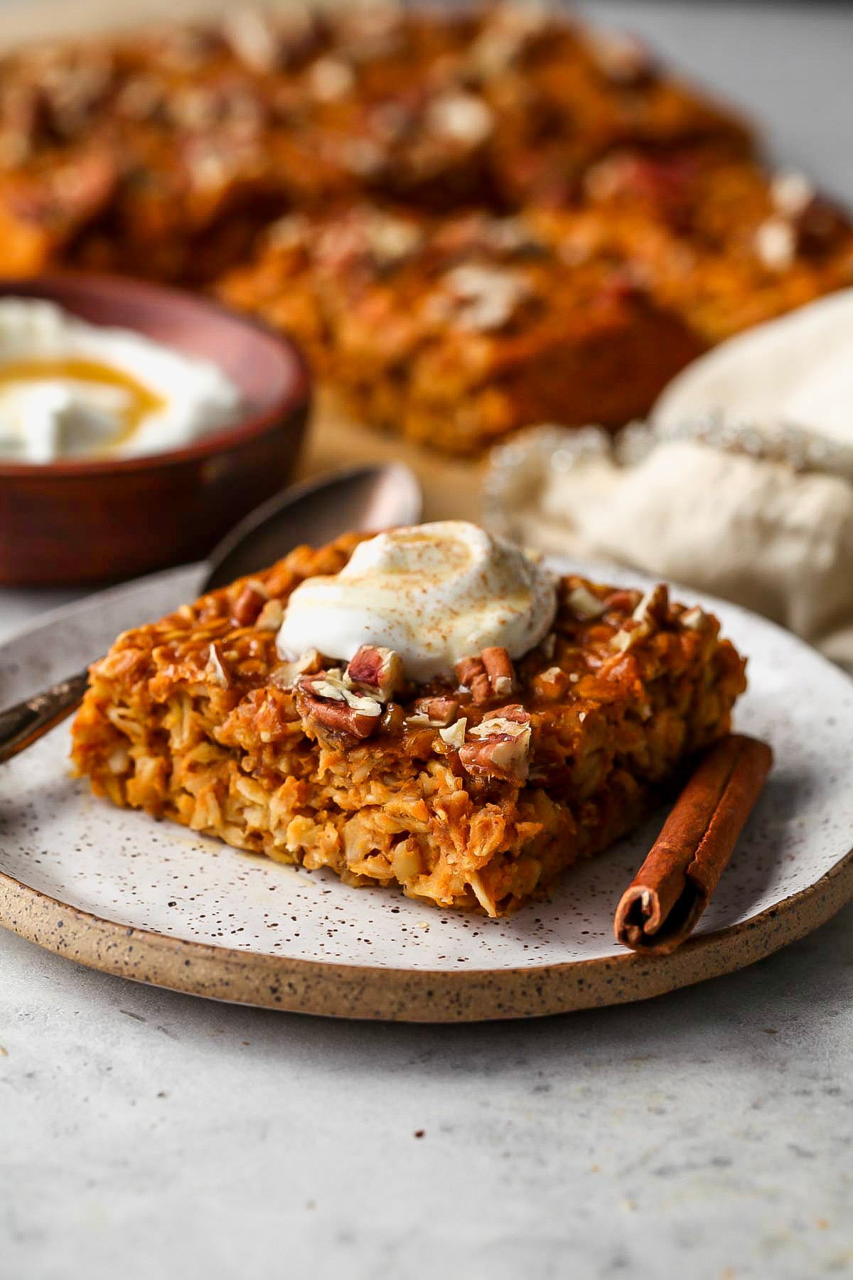 One square serving of baked pumpkin oats on a round white plate.