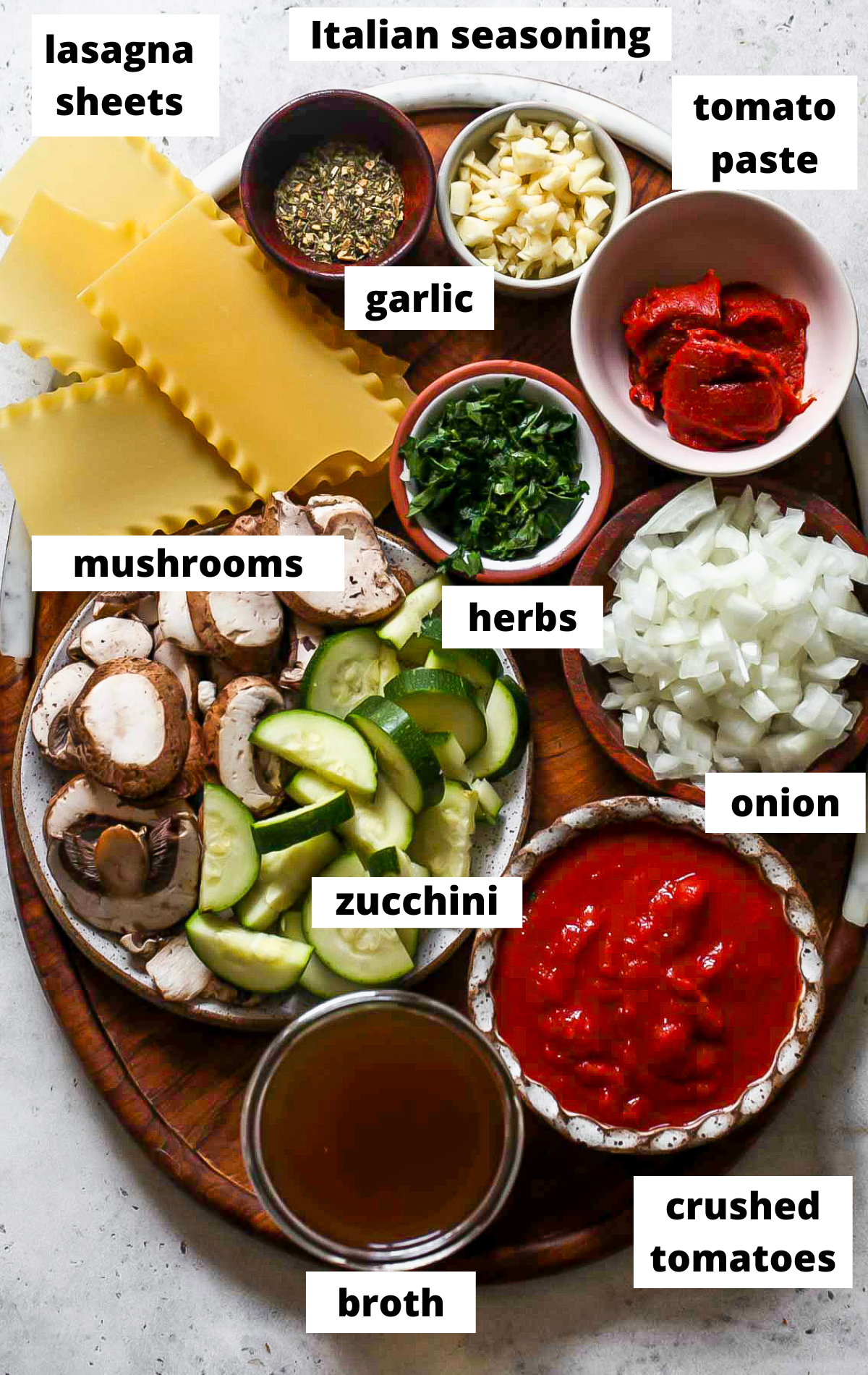 Recipe ingredients in separate bowls on a wooden platter with labels.