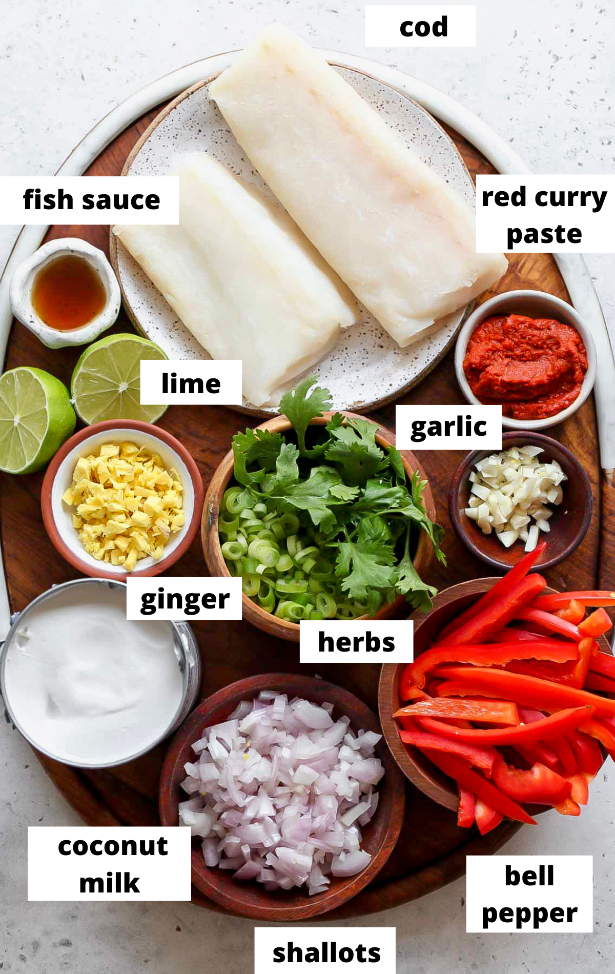 Recipe ingredients in separate bowls on a wooden platter with labels.