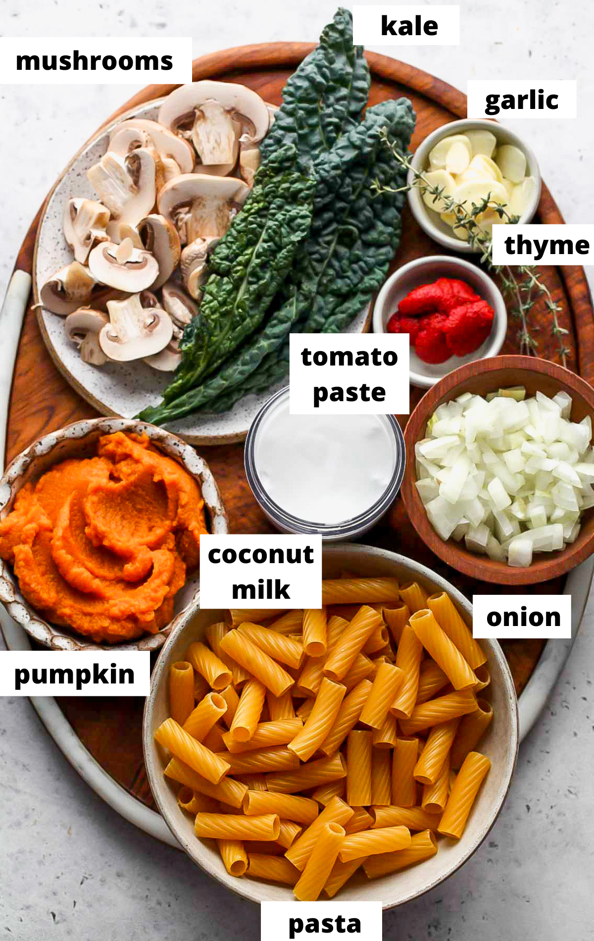Recipe ingredients in separate bowls on a wooden platter with labels.