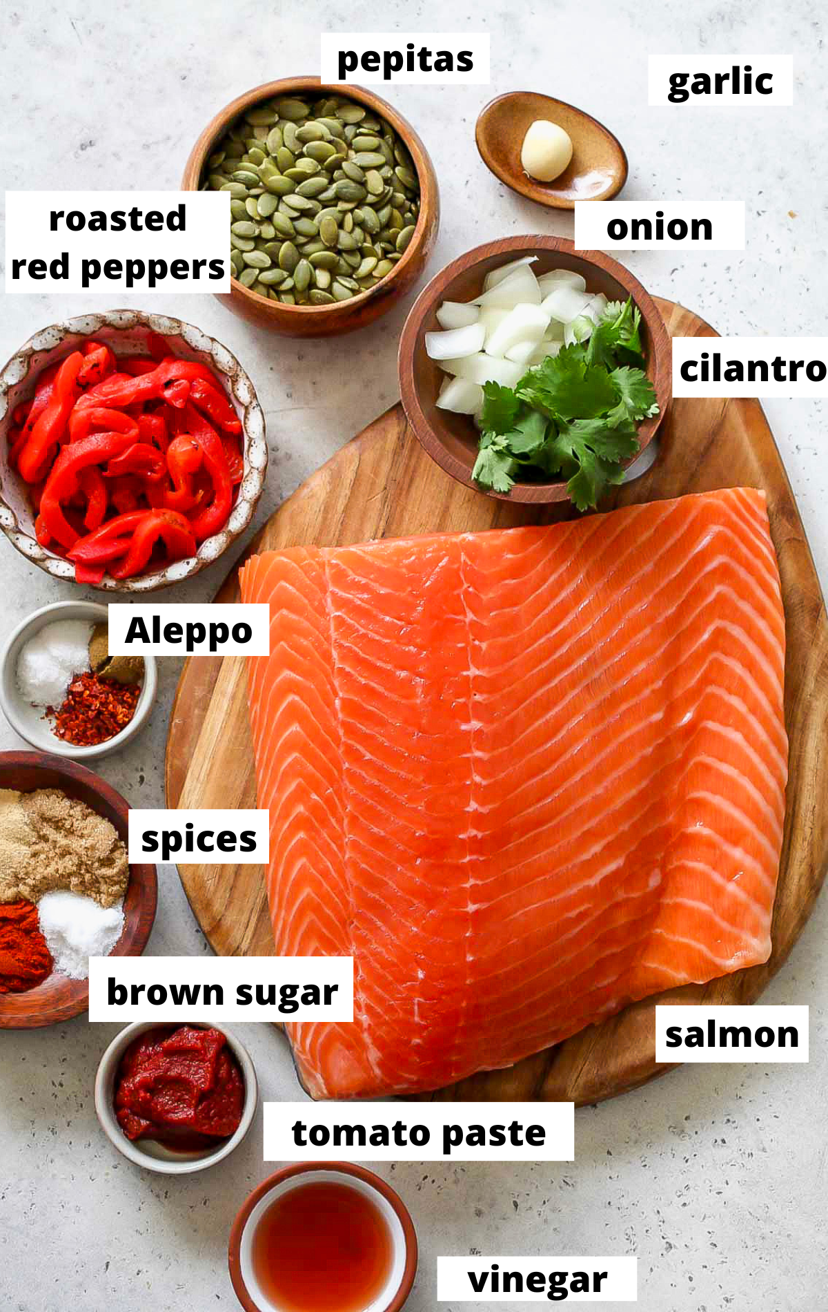 Recipe ingredients in separate bowls arranged on a wooden platter.