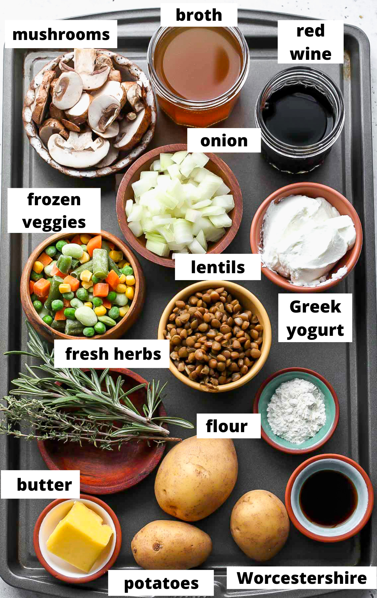 Recipe ingredients in separate bowls arranged on a baking sheet with labels.