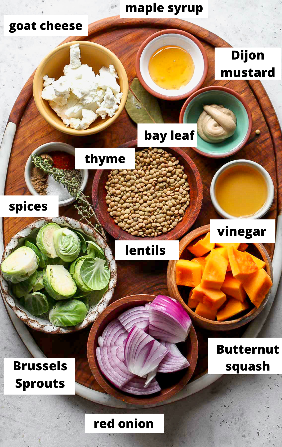 Recipe ingredients in separate bowls arranged on a wooden platter.