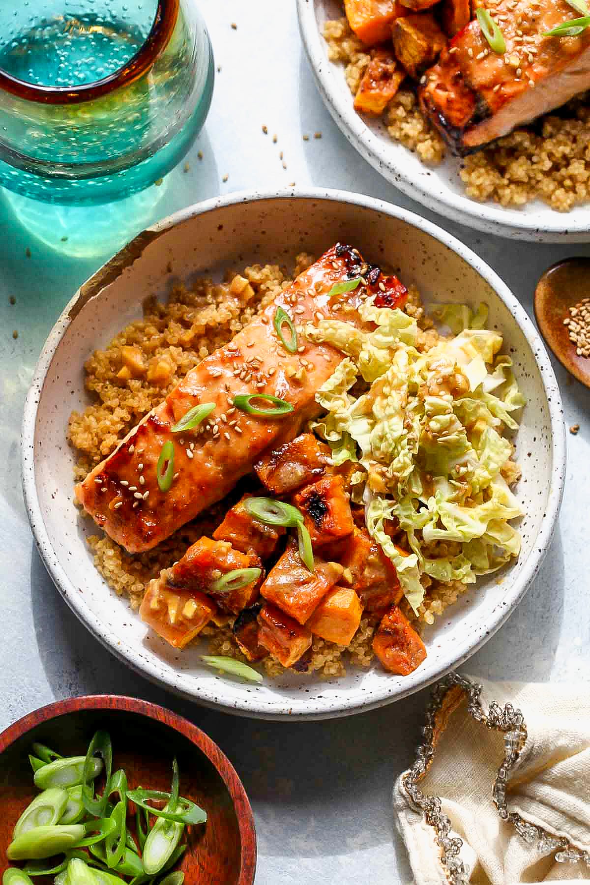Sheet Pan miso-ginger salmon and squash arranged over quinoa in a white bowl.