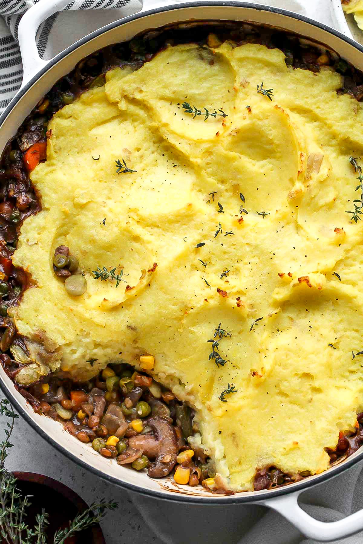 A scoop being taken out of a pan of shepherds pie to reveal filling.