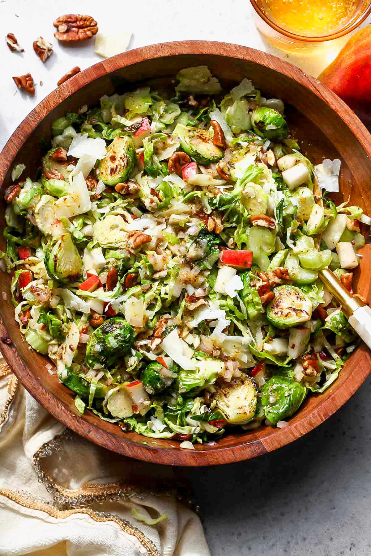 Brussels Salad with pear and pecans styled in a wooden serving bowl.