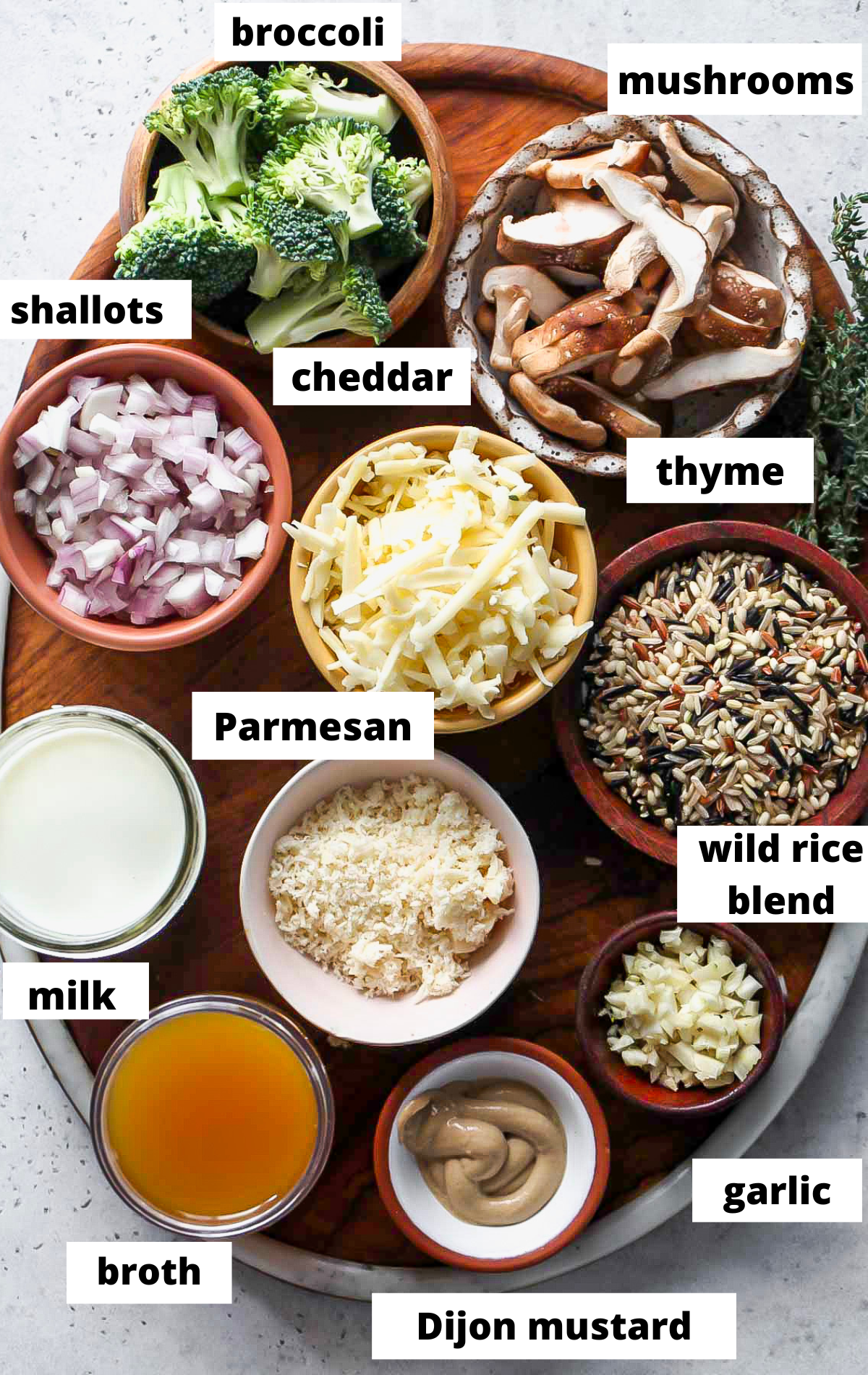 Recipe ingredients arranged on a wooden board in separate bowls with labels.