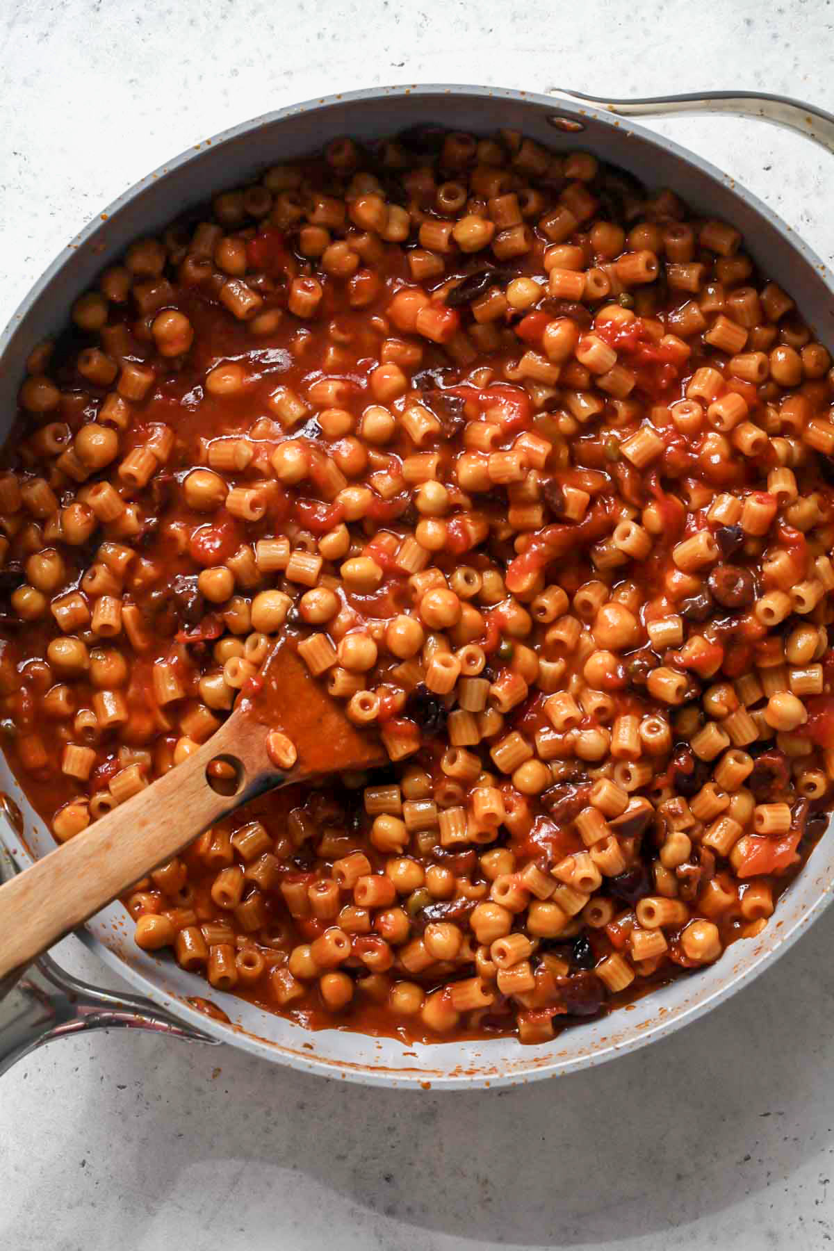 Past and chickpeas being added to skillet and cooked until al dente.