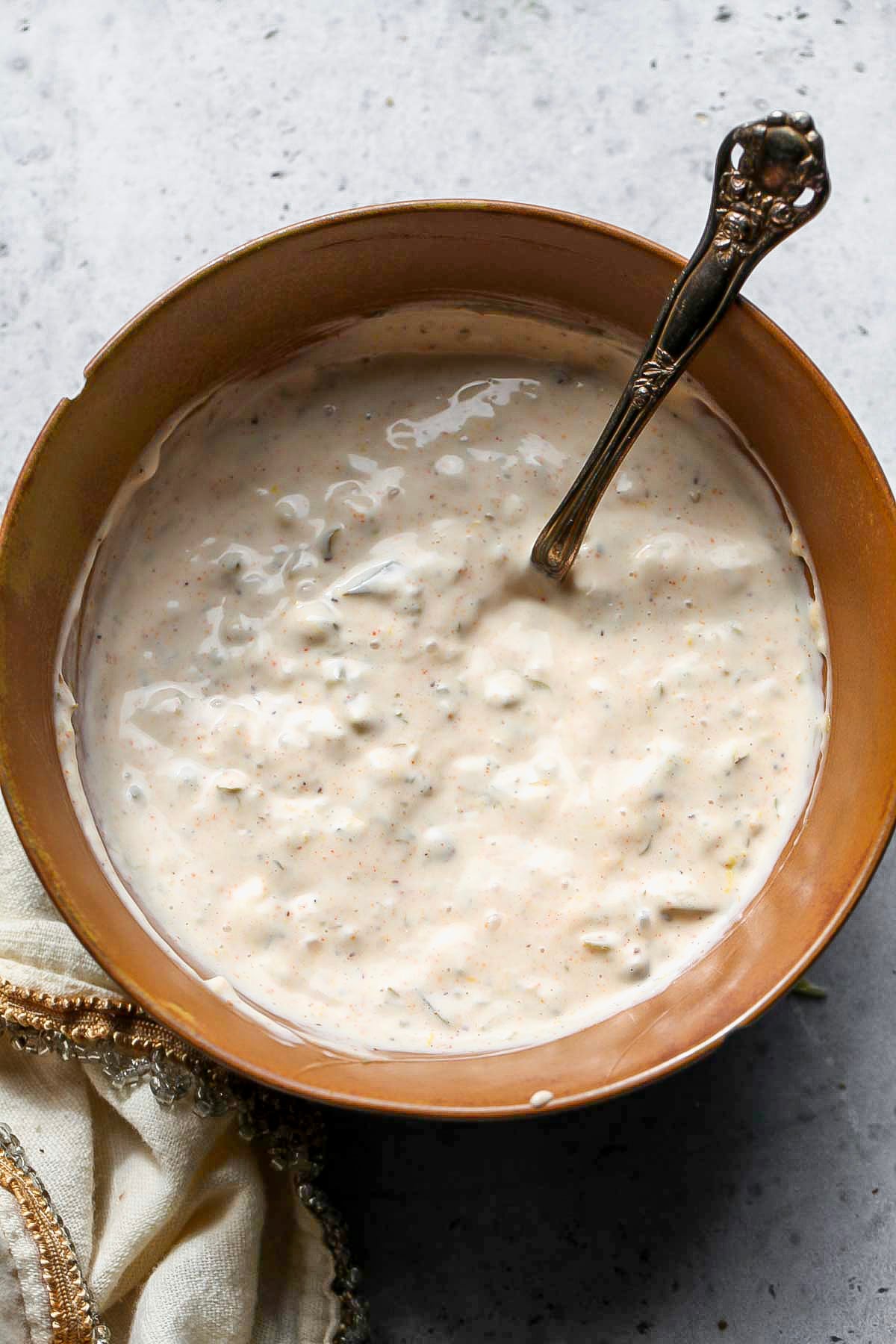 Old Bay Remoulade being mixed in a gold bowl.