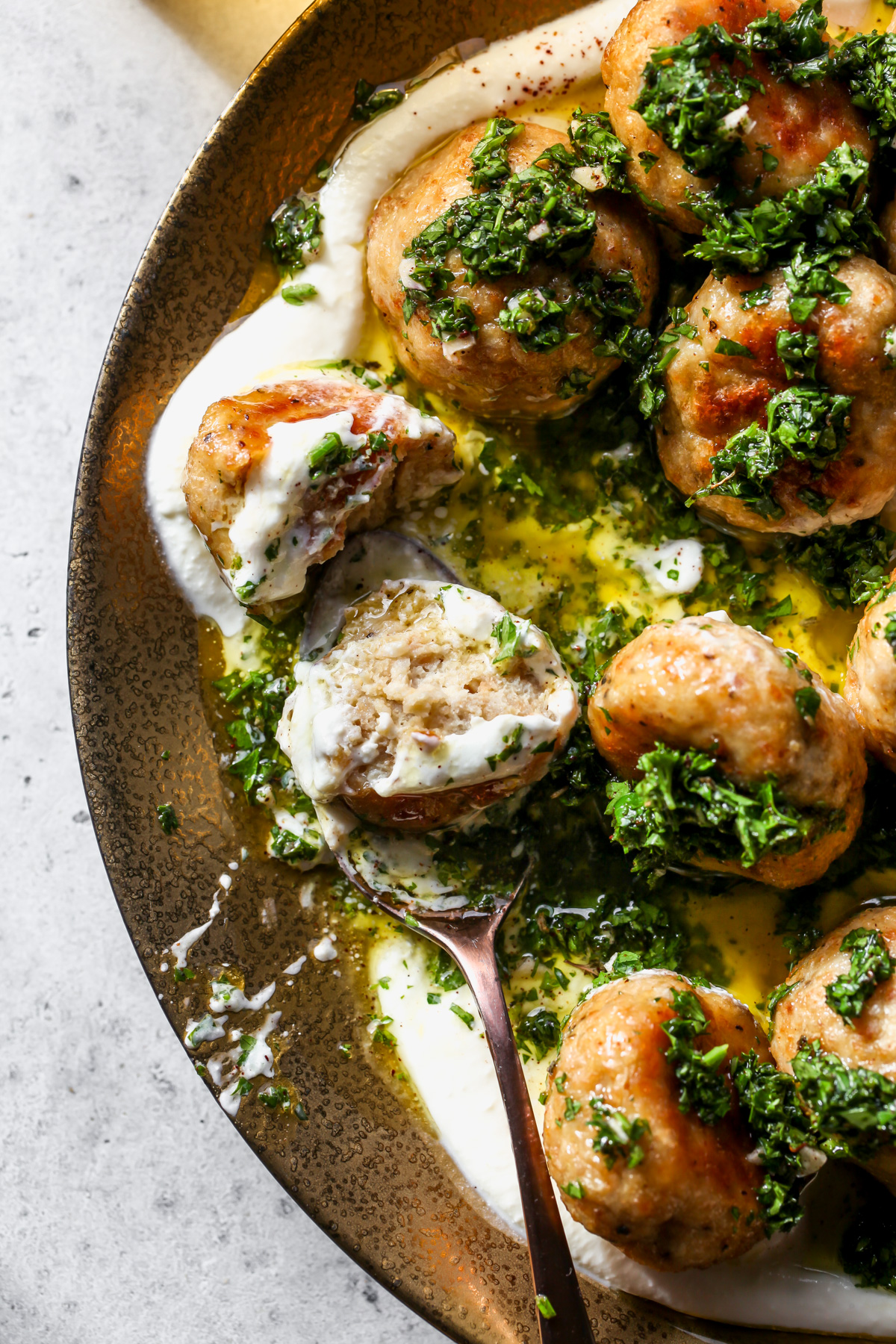 A baked chicken meatball being sliced into to reveal inside texture.
