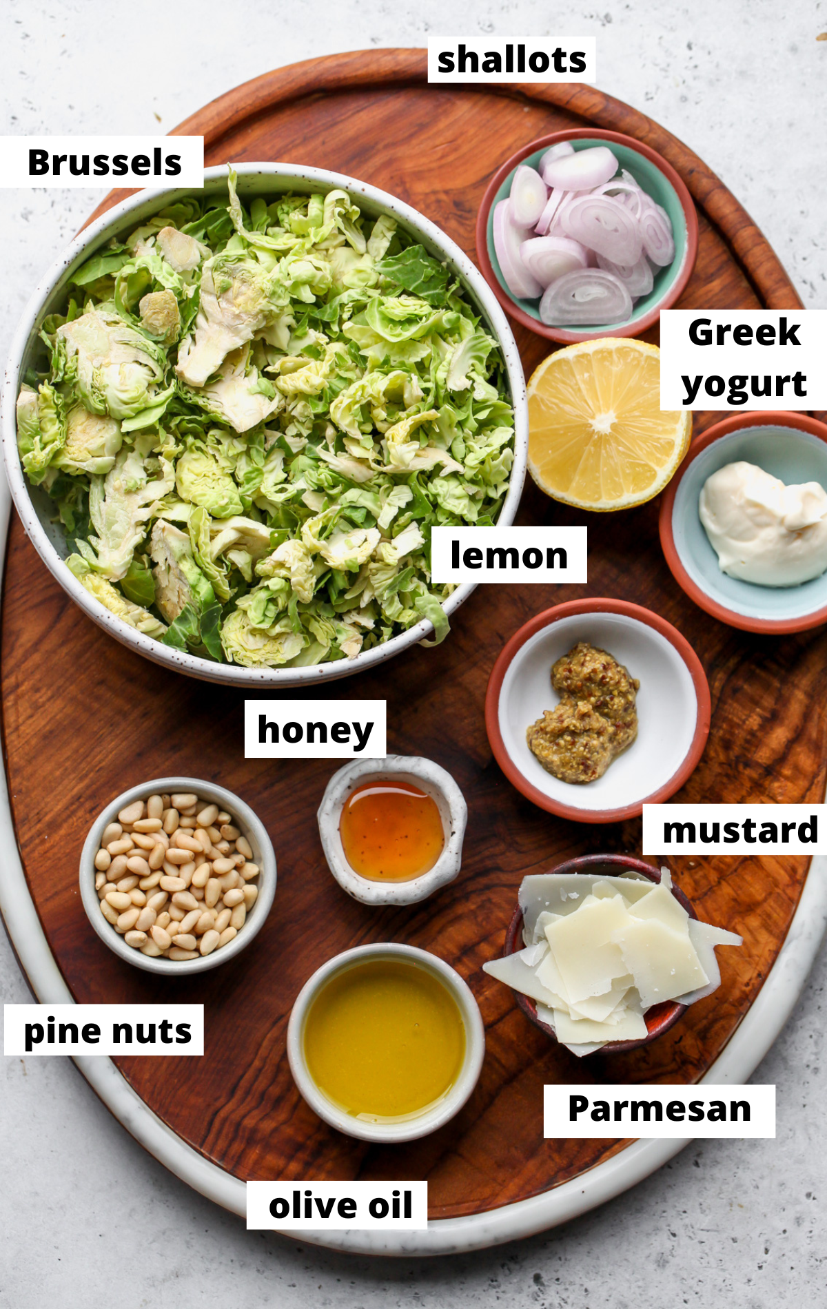 Recipe ingredients arranged in separate bowls on a wooden tray with labels.
