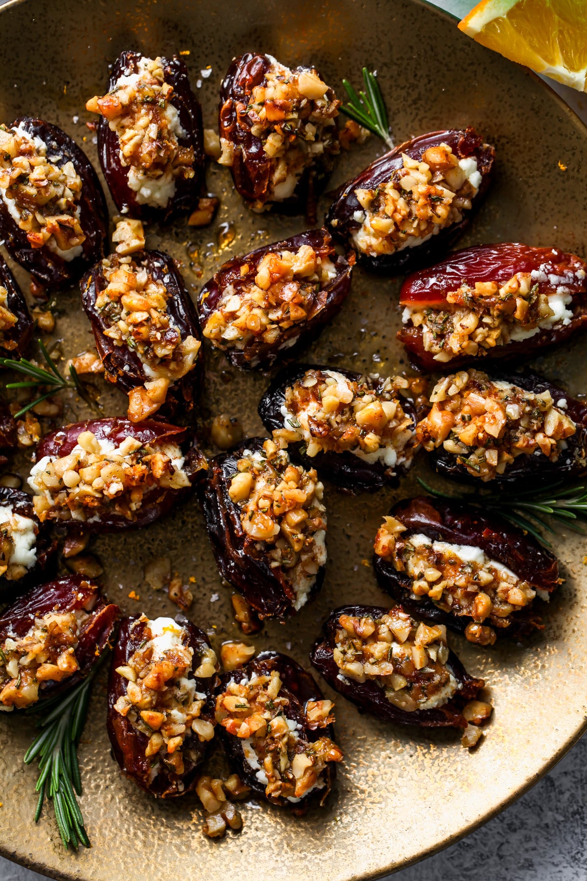 Goat cheese stuffed dates arranged on a gold serving plate.