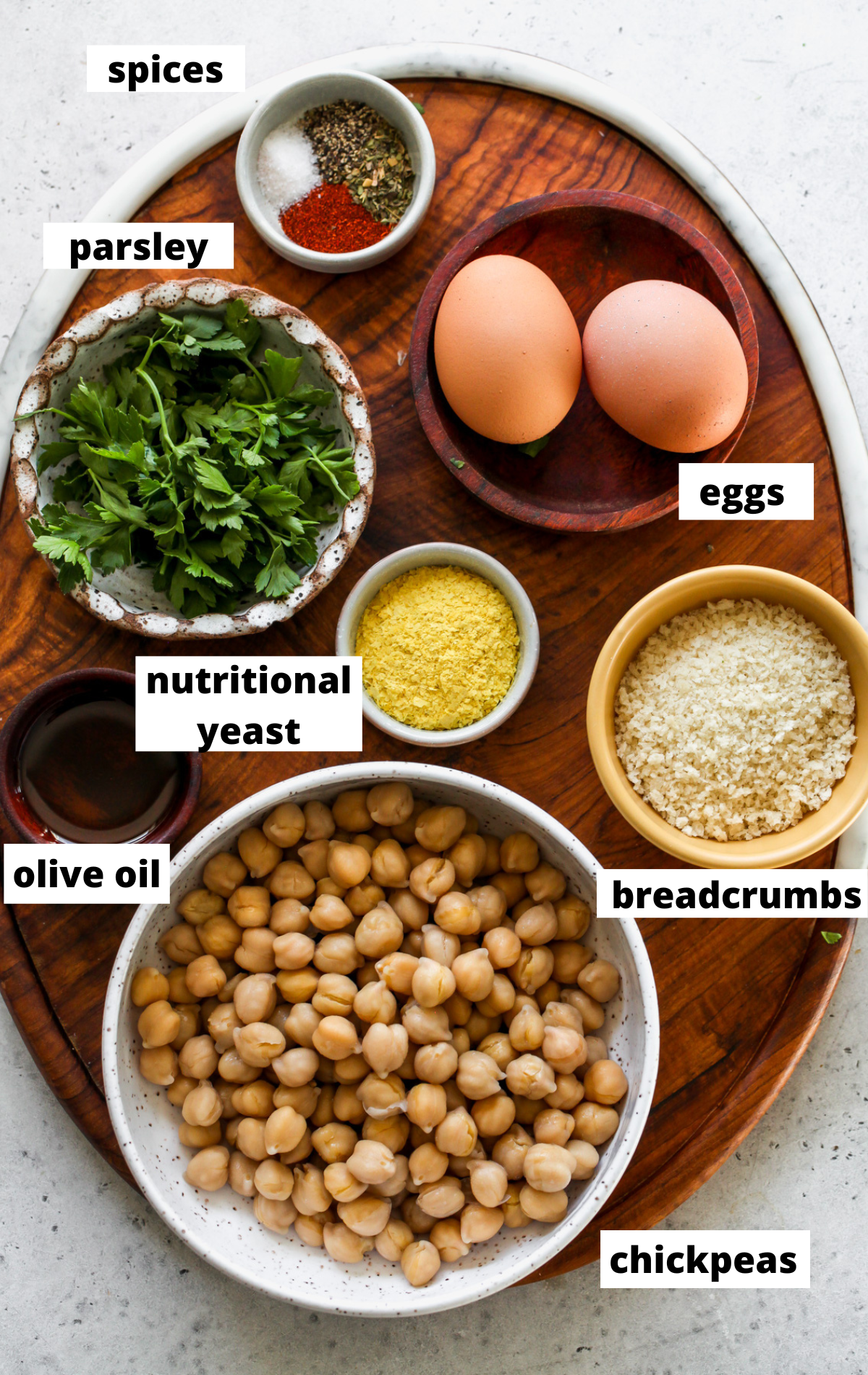 Recipe ingredients in bowls arranged on a wooden tray with labels.