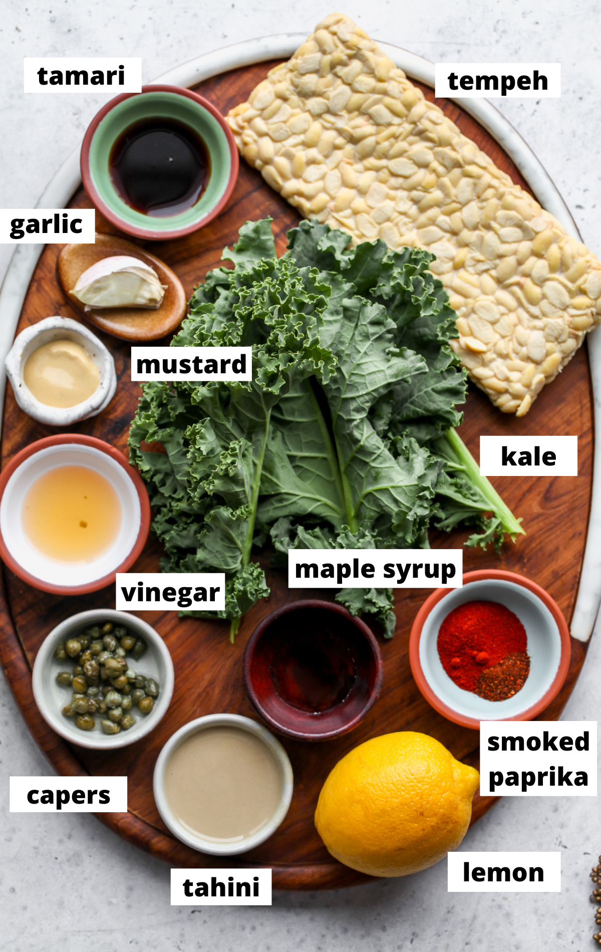 Recipe ingredients arranged in separate bowls on a wooden serving tray.