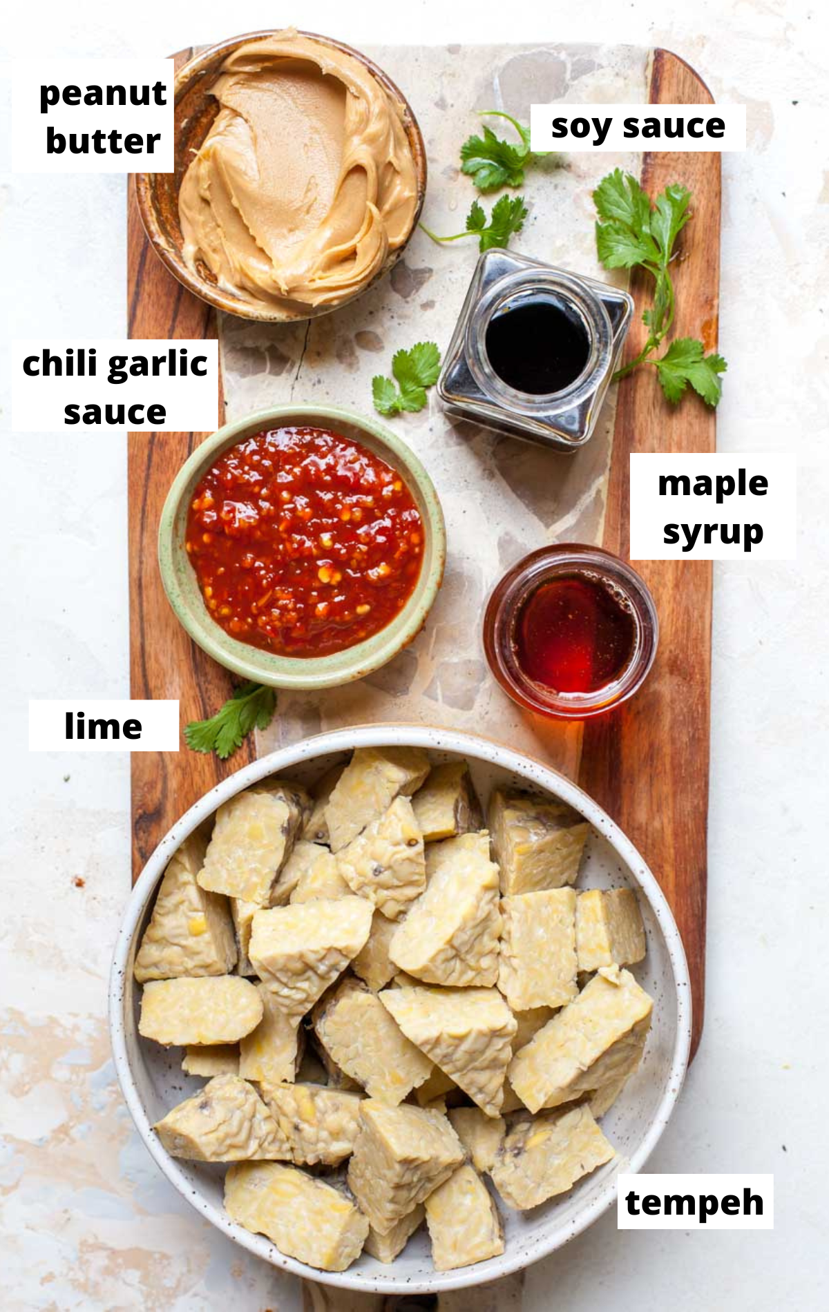 Recipe ingredients arranged in separate bowls on a serving board with labels.