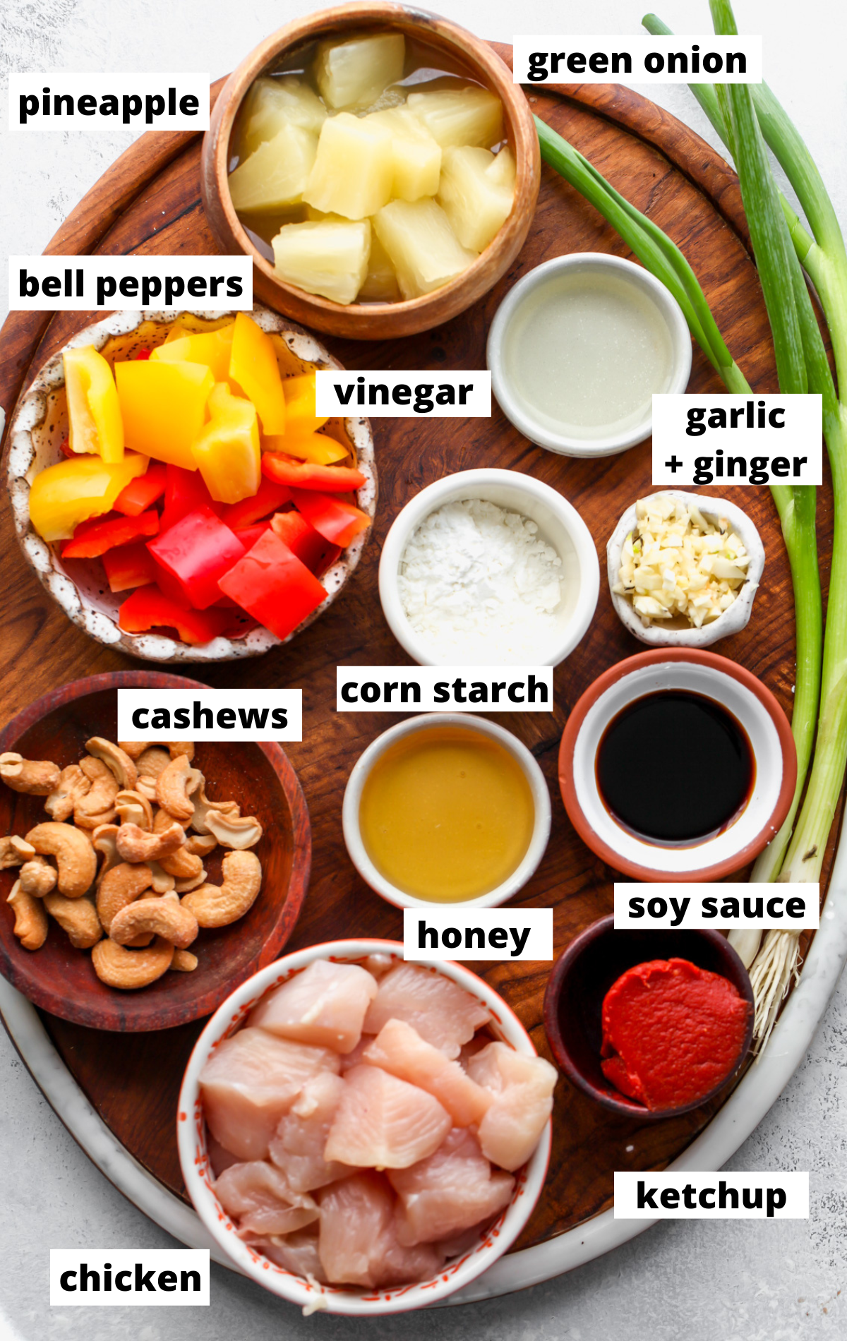Recipe ingredients in separate bowls with labels arranged on a wooden board.