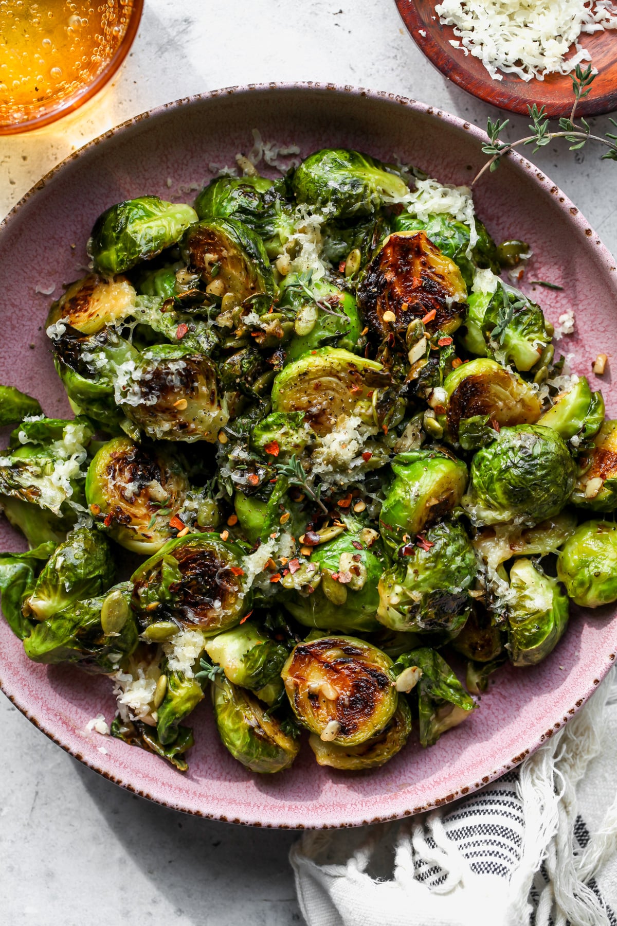 Crispy Brussels Sprouts tossed in maple-mustard glaze in a pink bowl.