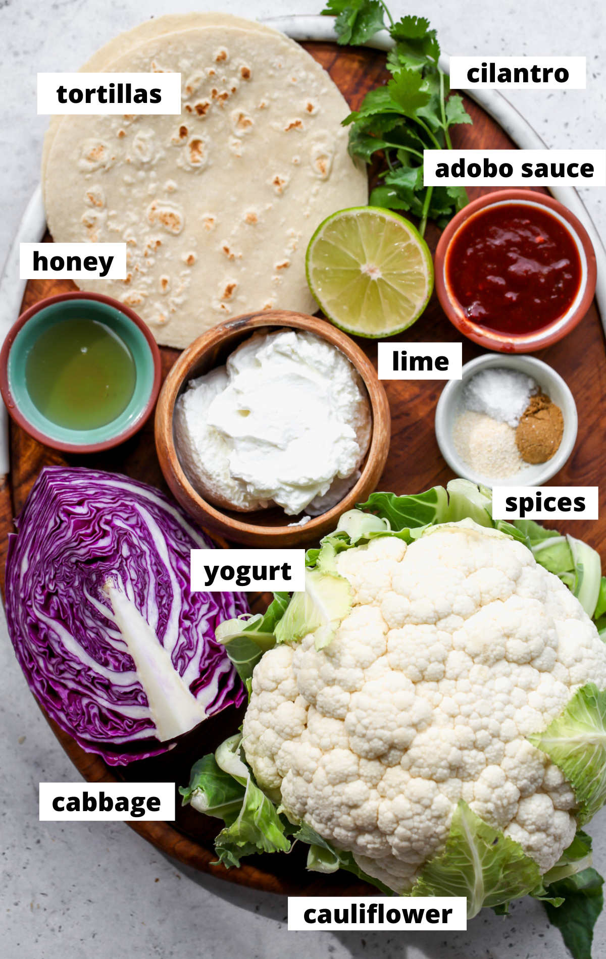 Recipe ingredients arranged on a wooden platter with labels.