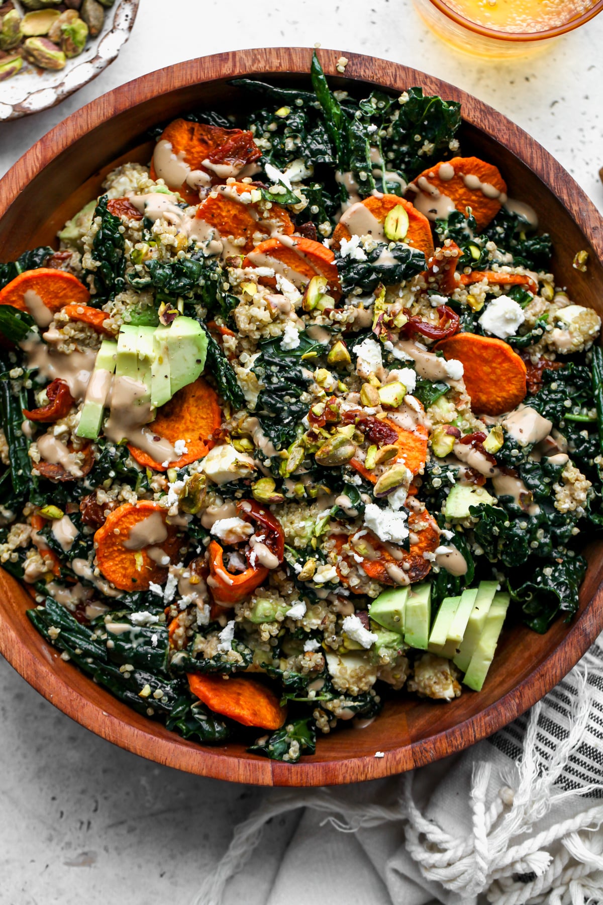 Kale and sweet potato salad styled in a wooden serving bowl.