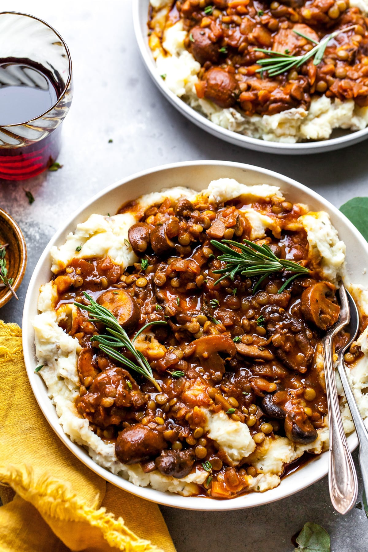 Lentil and Mushroom Stew over Potato-Parsnip Mash styled in a white bowl. Fork resting on the right side.