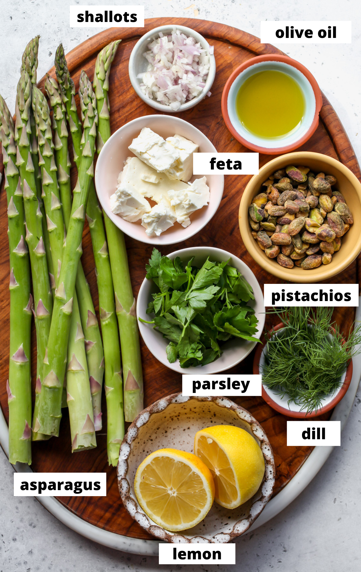 Recipe ingredients in separate bowls arranged on a wooden platter with labels.