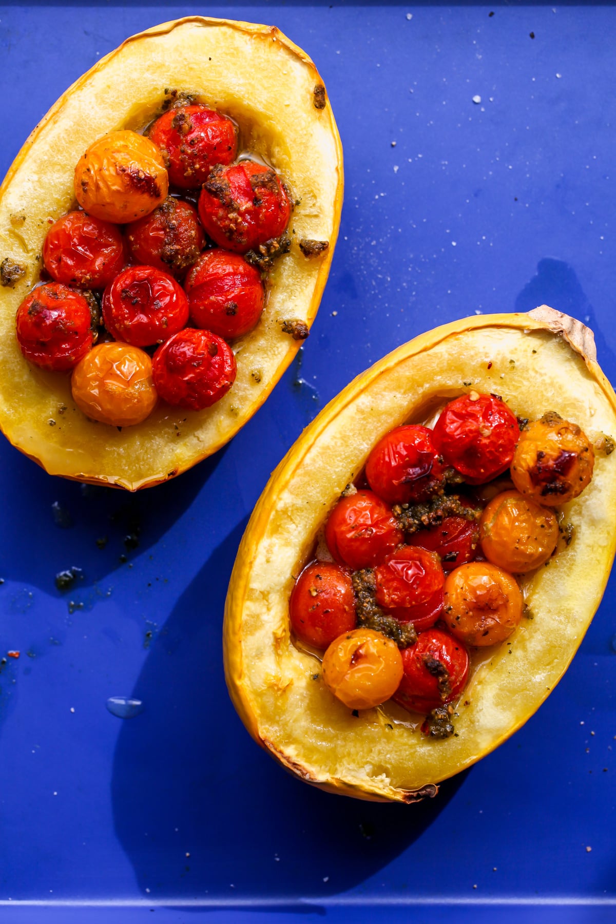 Tomato-Pesto Baked Feta Spaghetti Squash arranged on a blue baking sheet after being baked.