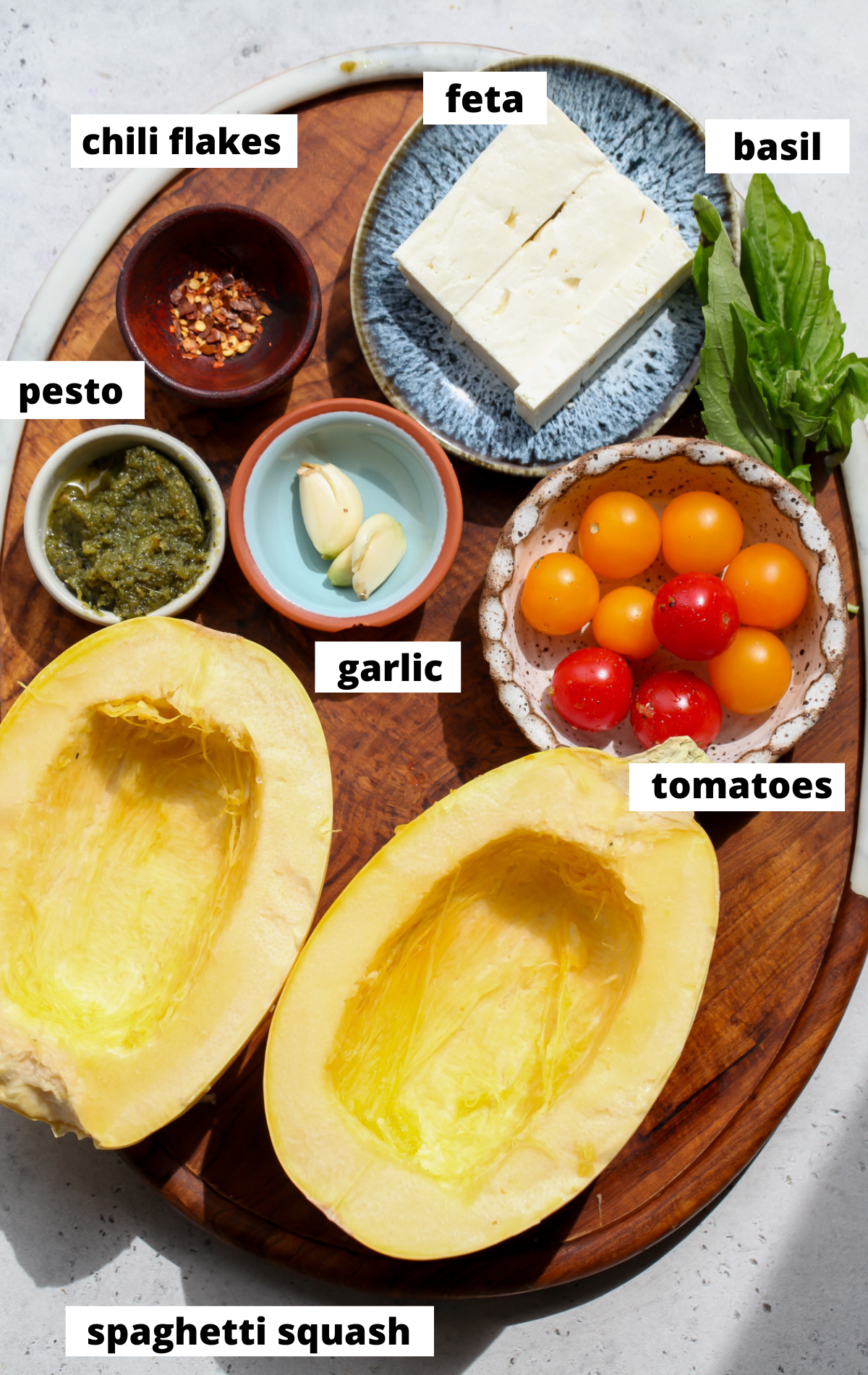 Recipe ingredients arranged in separate bowls on a wooden board with labels.