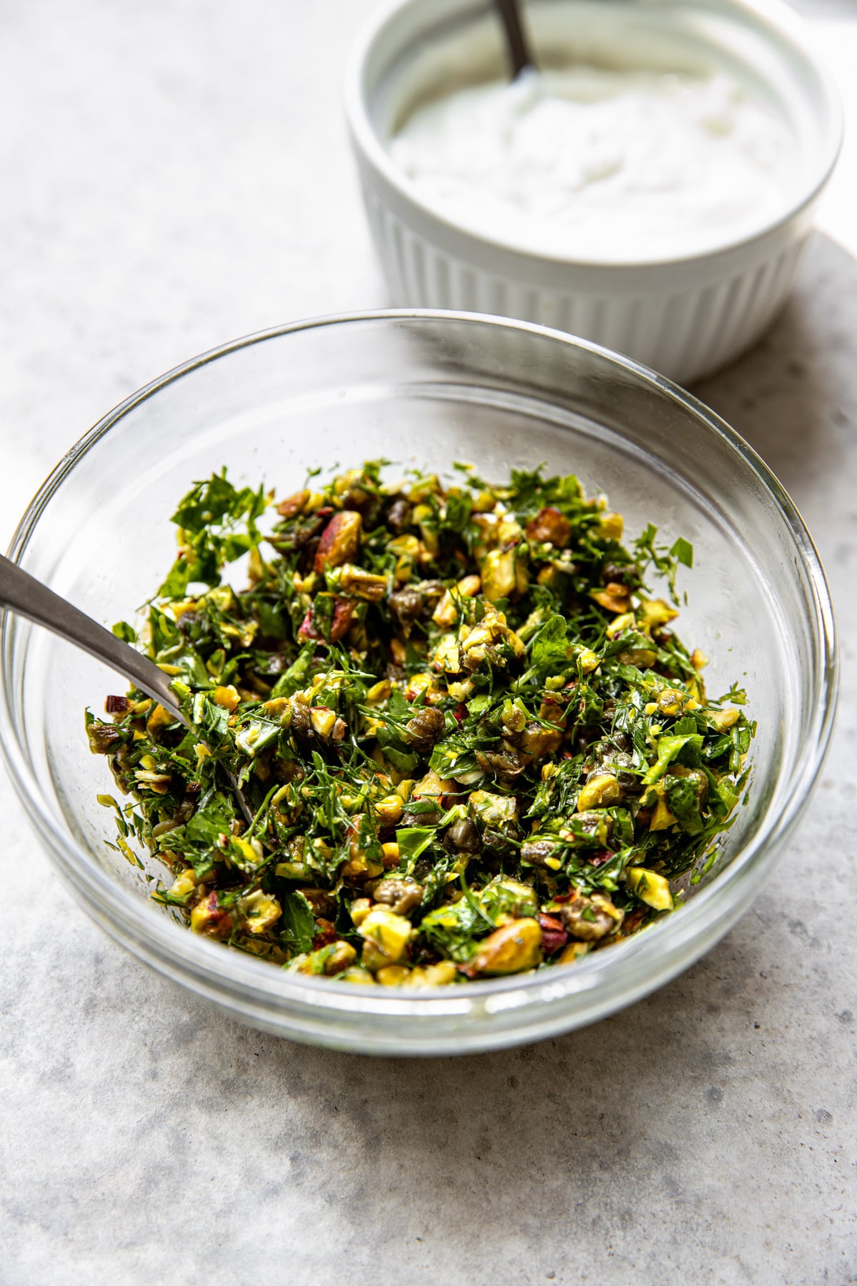 Gremolata being mixed in a clear glass bowl.