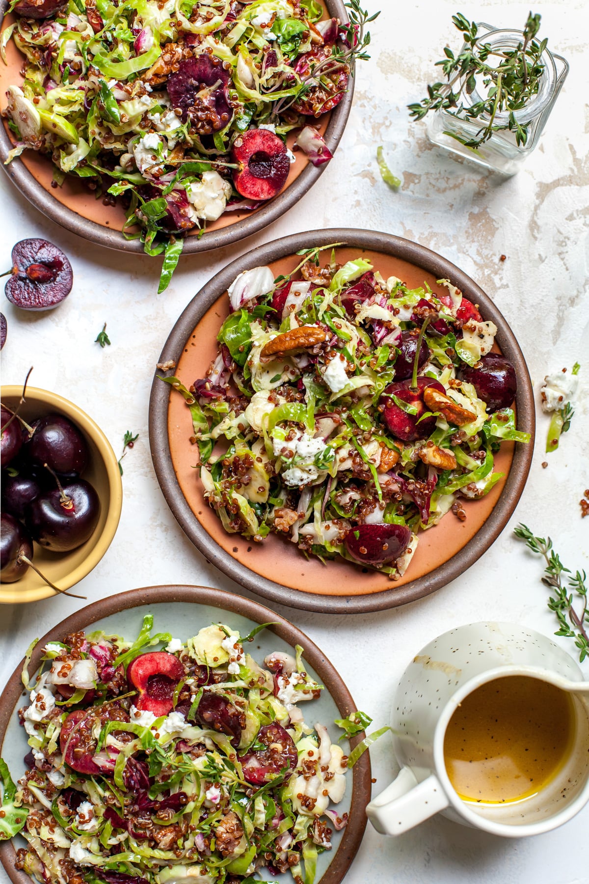 Cherry salad arranged on three small salad plates on a white surface.