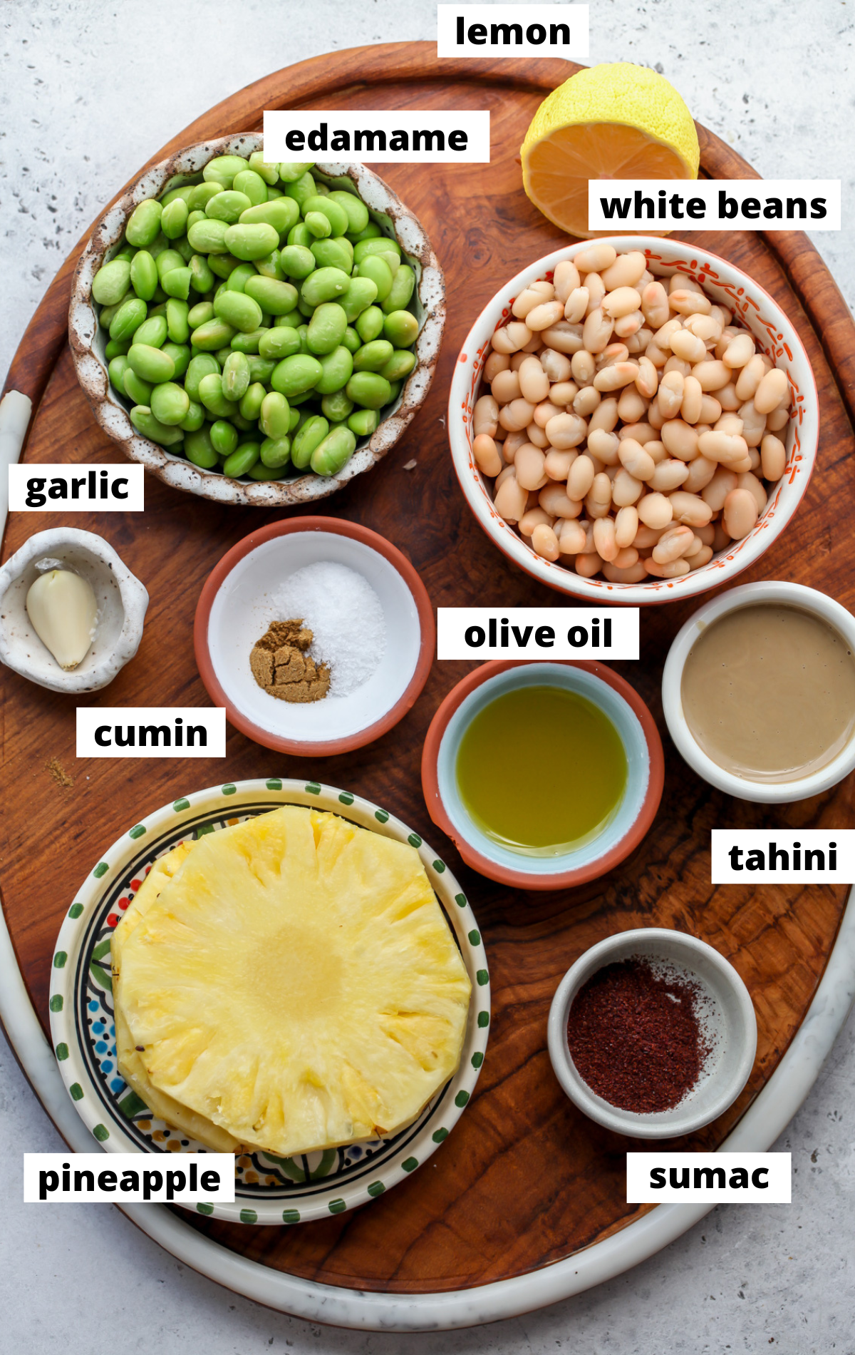 Recipe ingredients in separate bowls on a wooden board with labels.