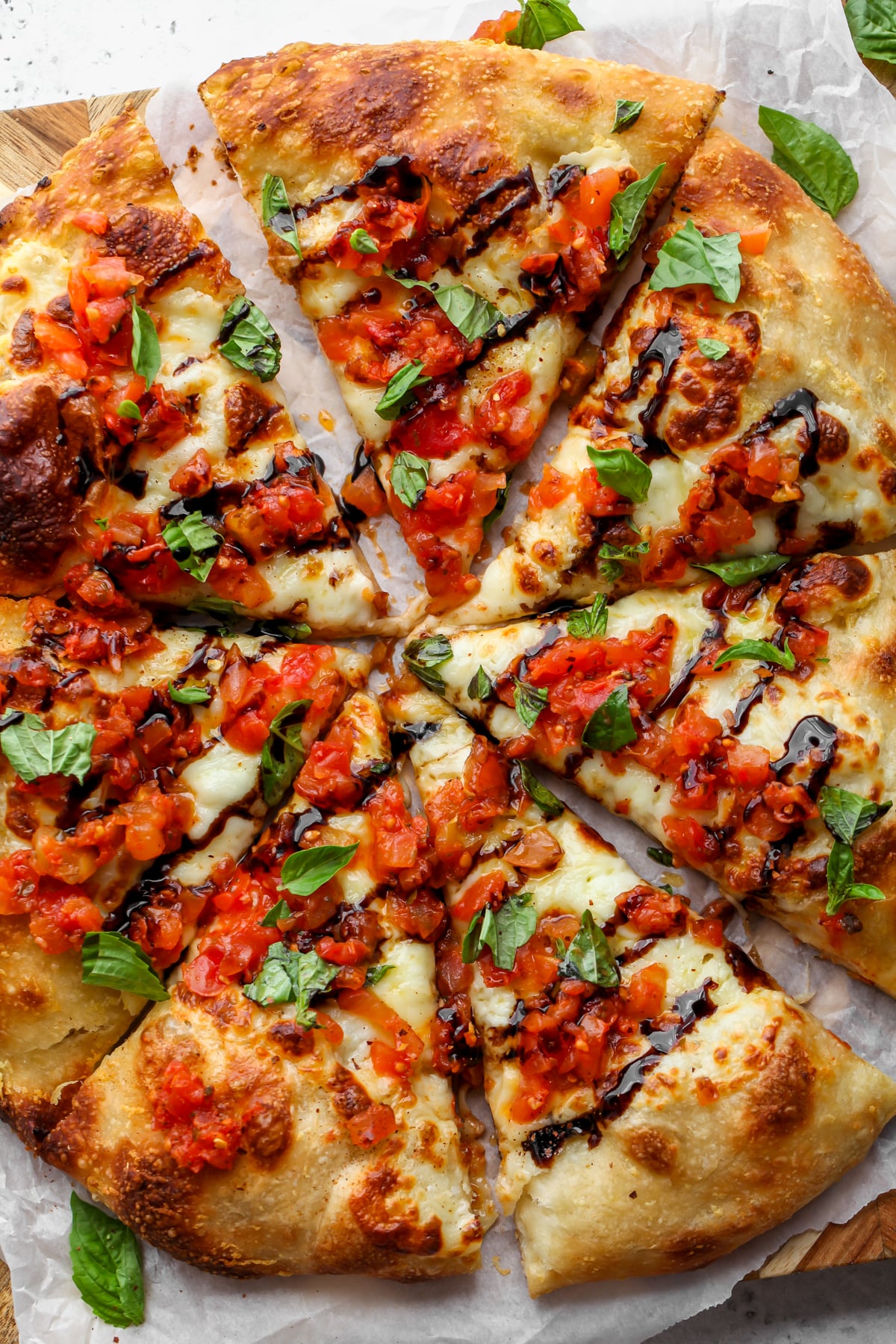 Bruschetta Pizza sliced on a cutting board.