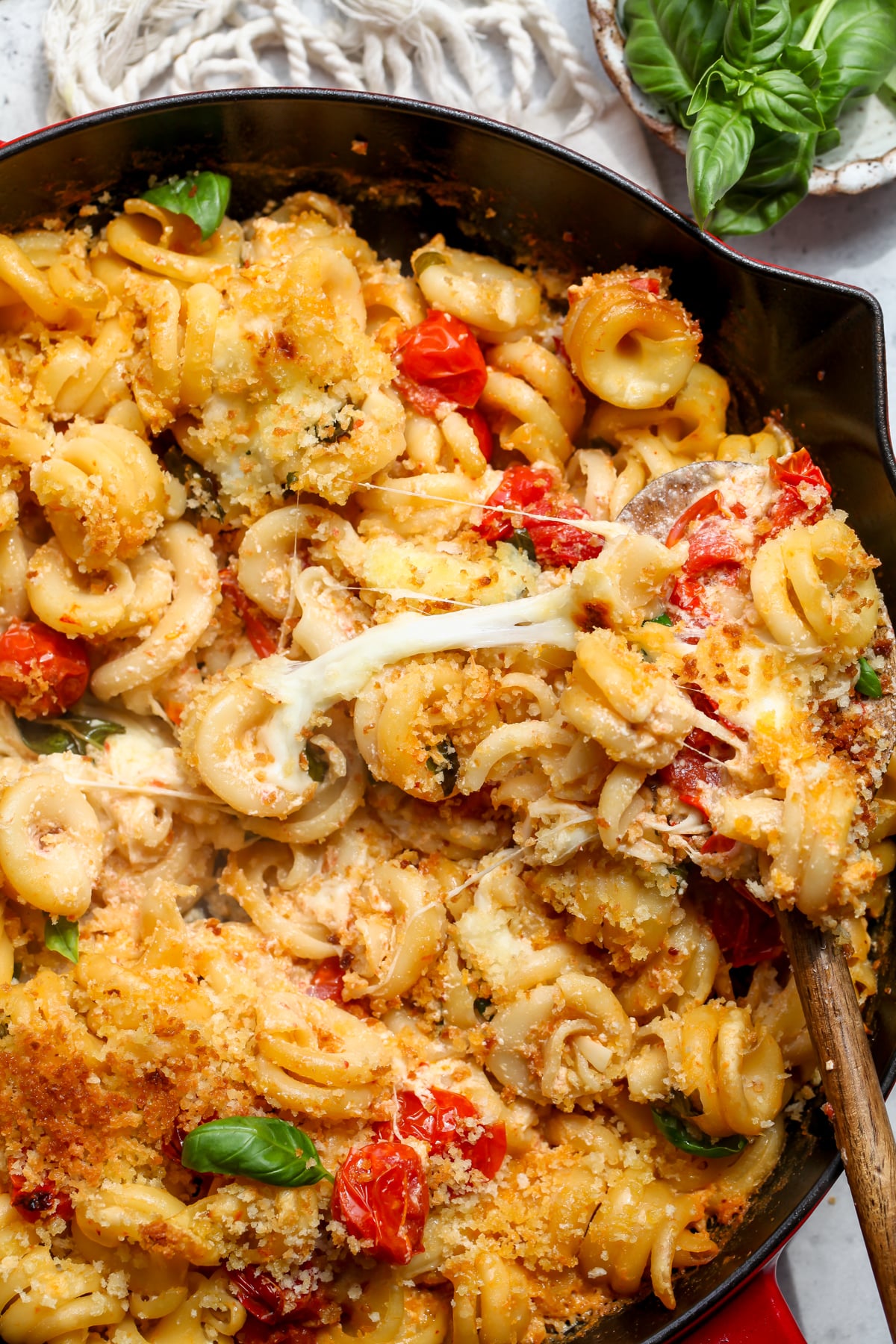 A wooden spoon stirring through a pot of mac and cheese to show cheese pulling.