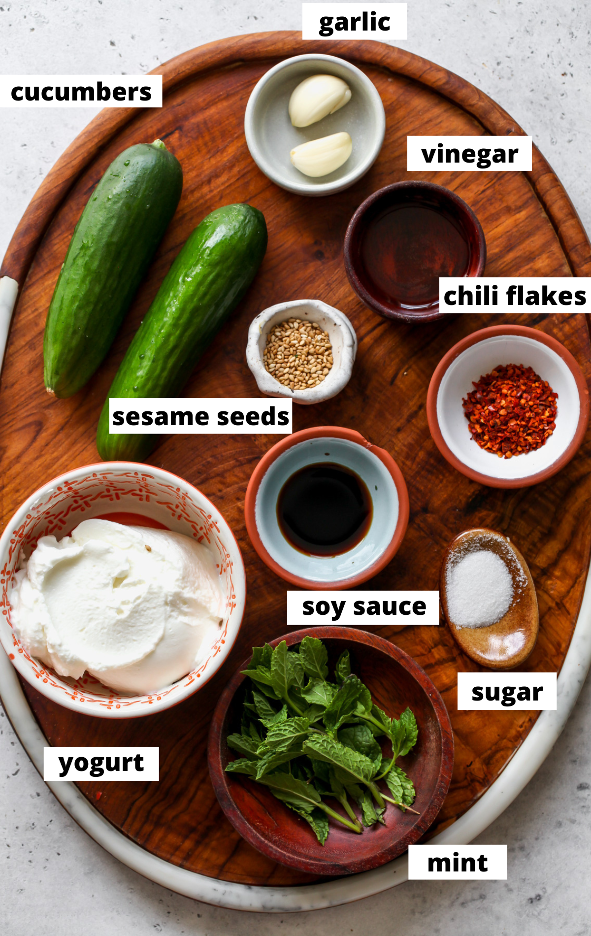 Recipe ingredients arranged on a wooden platter in separate bowls with labels.