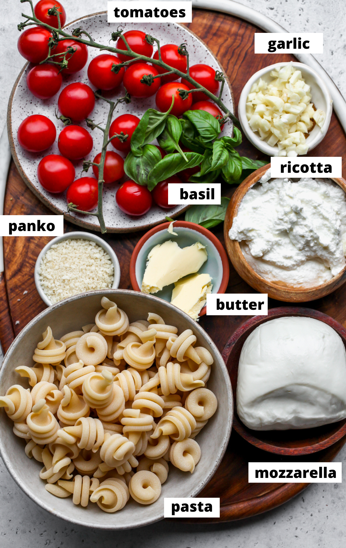 Recipe ingredients in separate bowls arranged on a wooden board with labels.