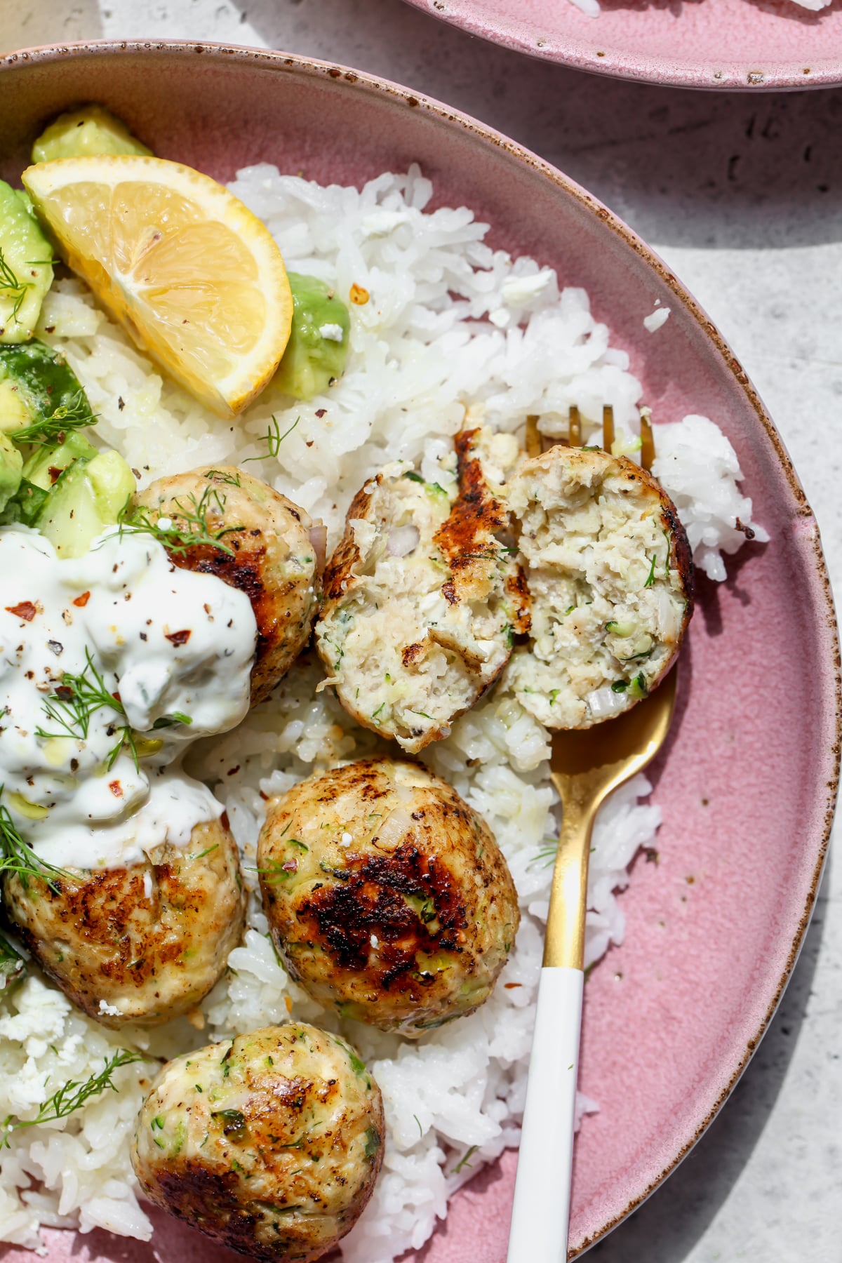 A chicken meatball being sliced in half to reveal inside texture.
