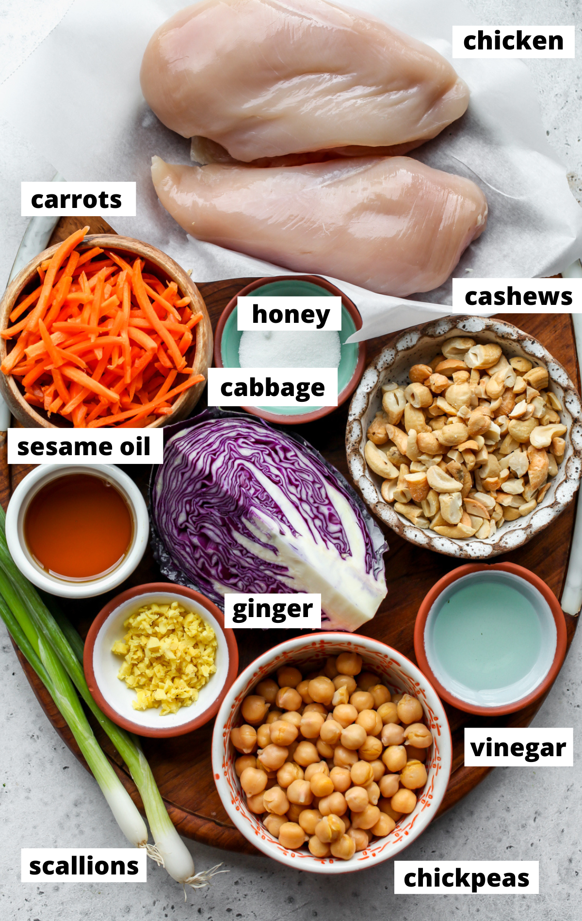 Recipe ingredients arranged on separate bowls on a wooden board with labels.