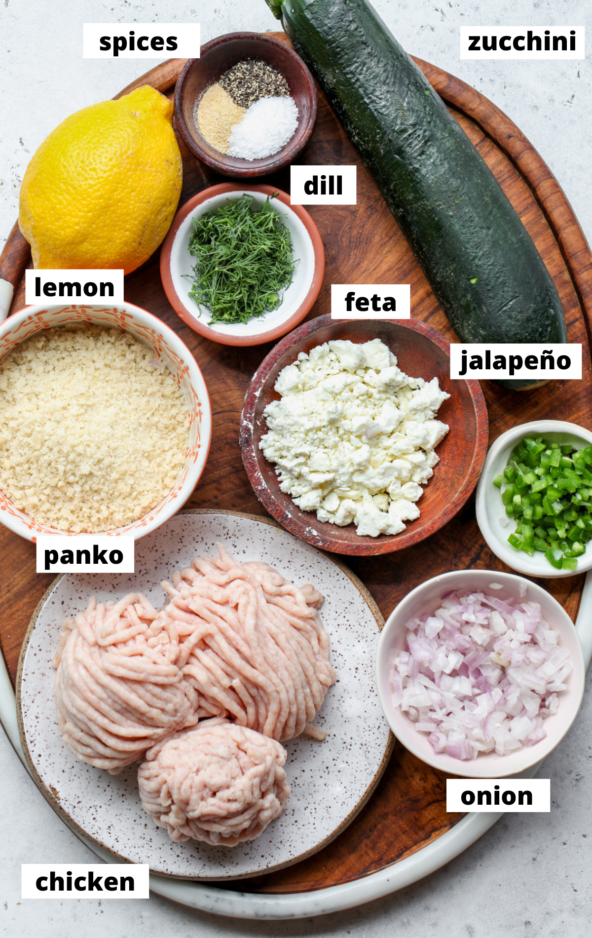 Recipe ingredients in separate bowls arranged on a wooden platter.