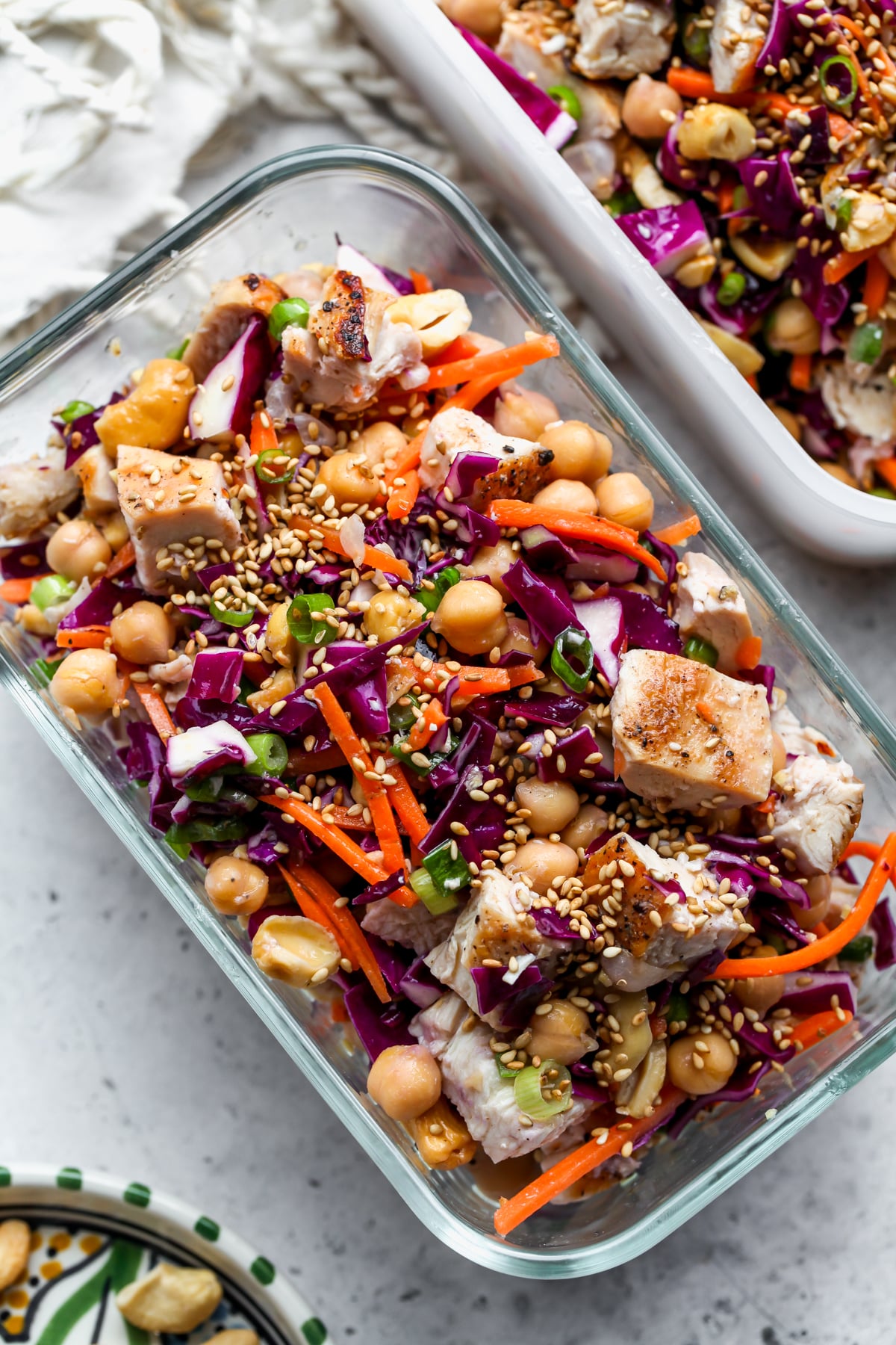 Sesame Chicken and Chickpea Salad in a Tupperware container assembled on a gray surface.