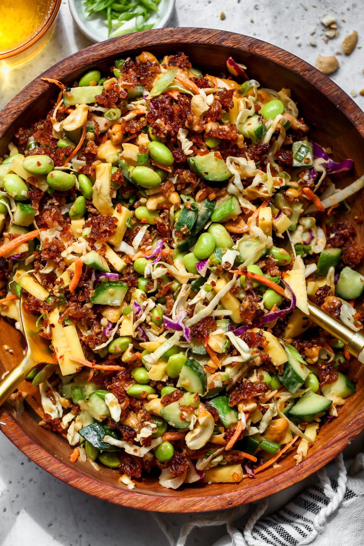 Crispy rice salad being tossed in a large wooden salad bowl.