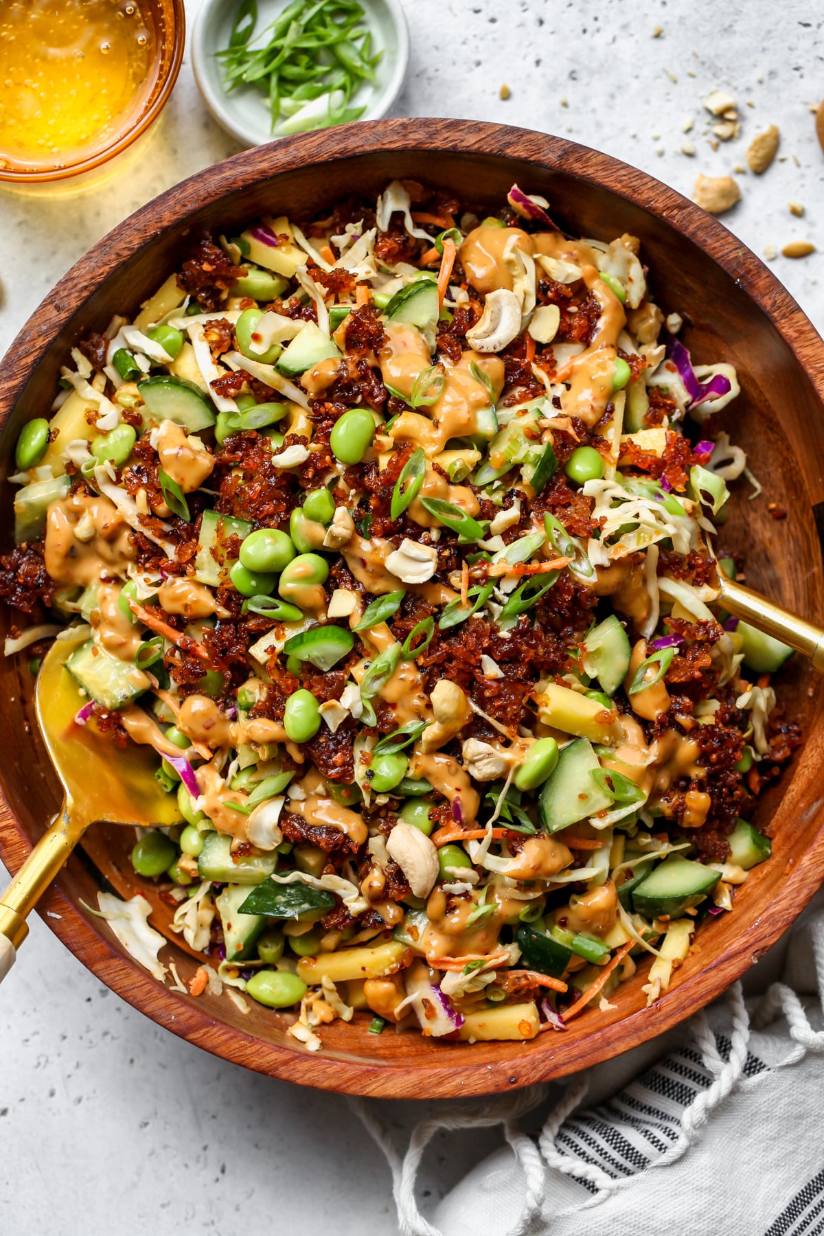 Crispy rice salad with chili crisp tahini dressing styled in a large wooden bowl.