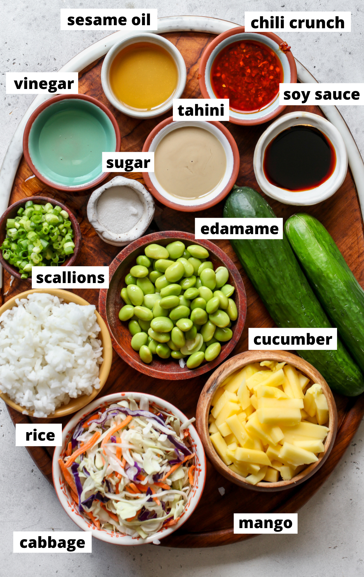 Recipe ingredients in separate bowls arranged on a wooden board with labels.