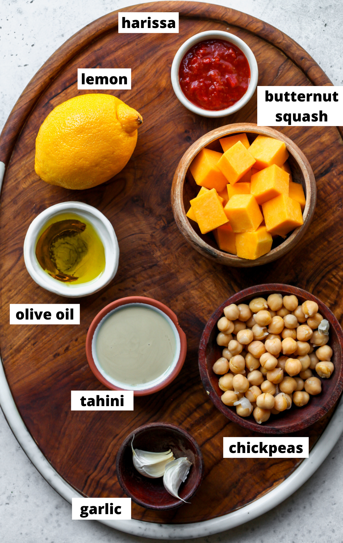 Recipe ingredients in separate bowls arranged on a wooden board with labels.