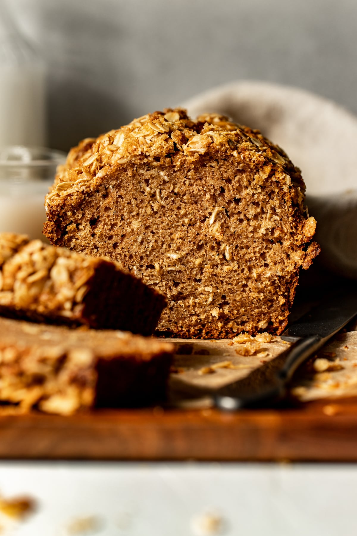 An inside look at a loaf of Apple Oatmeal Bread on a wooden cutting board.