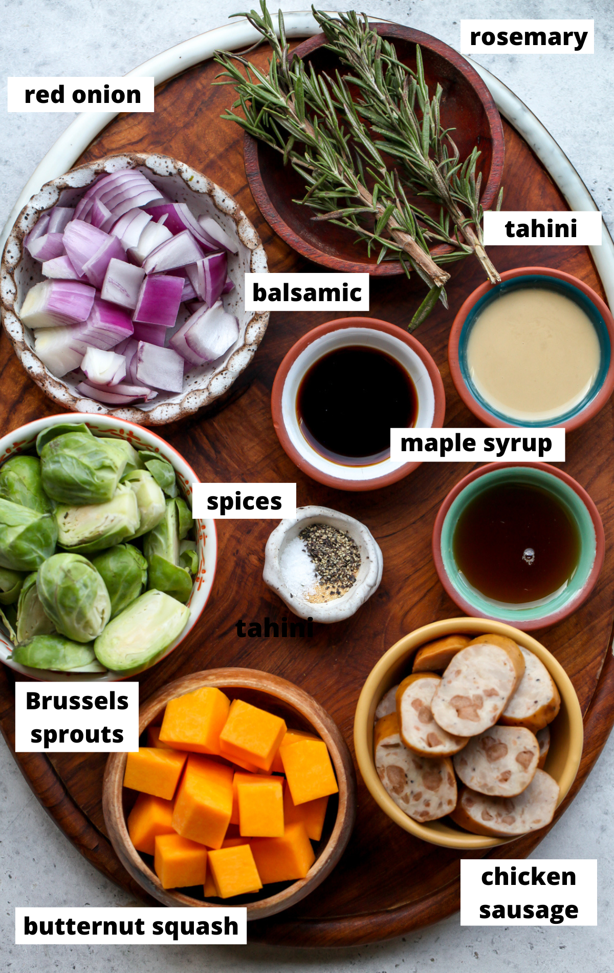 Recipe ingredients in separate bowls arranged on a wooden board with labels.