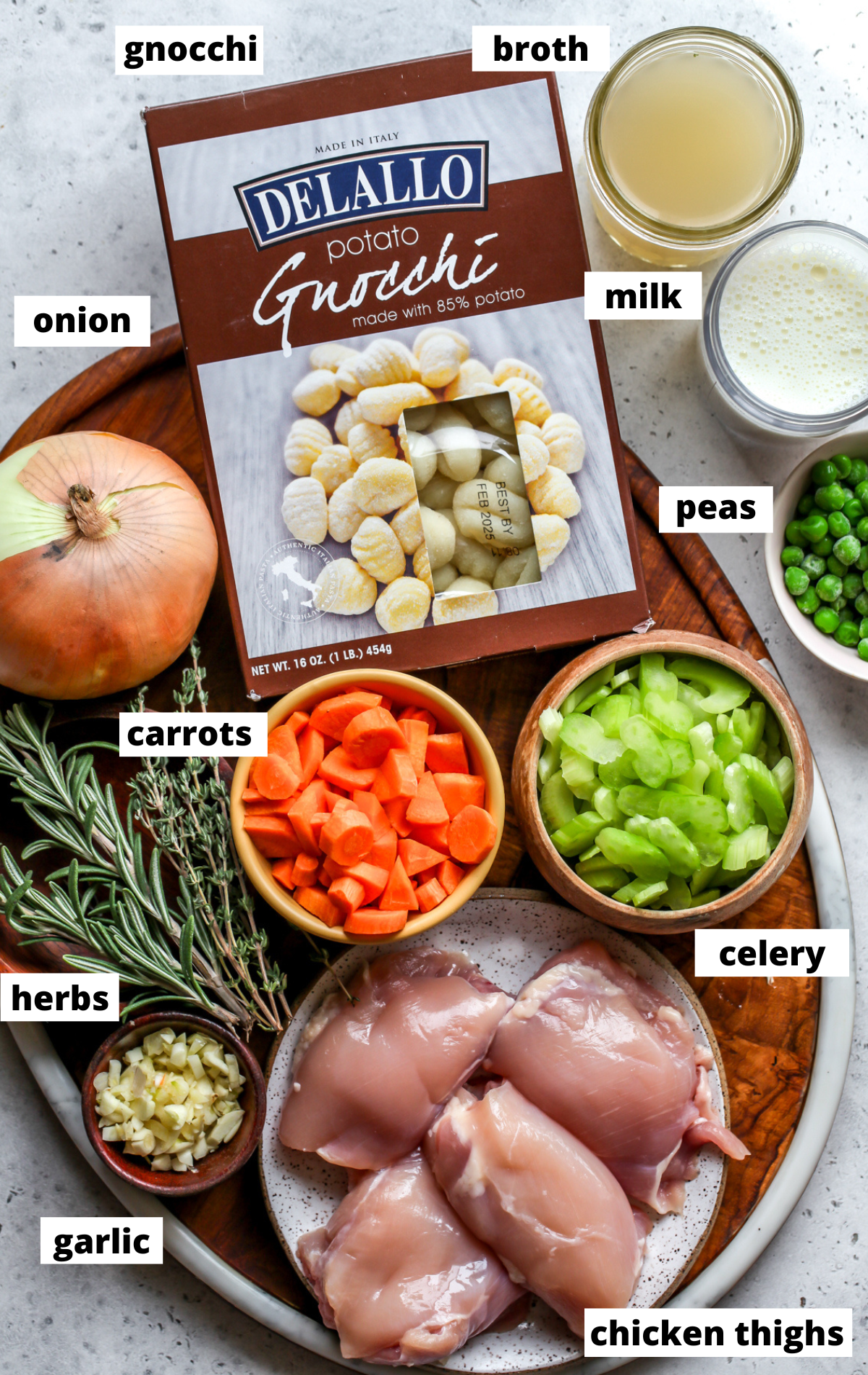 Recipe ingredients in separate bowls arranged on a wooden platter with labels.