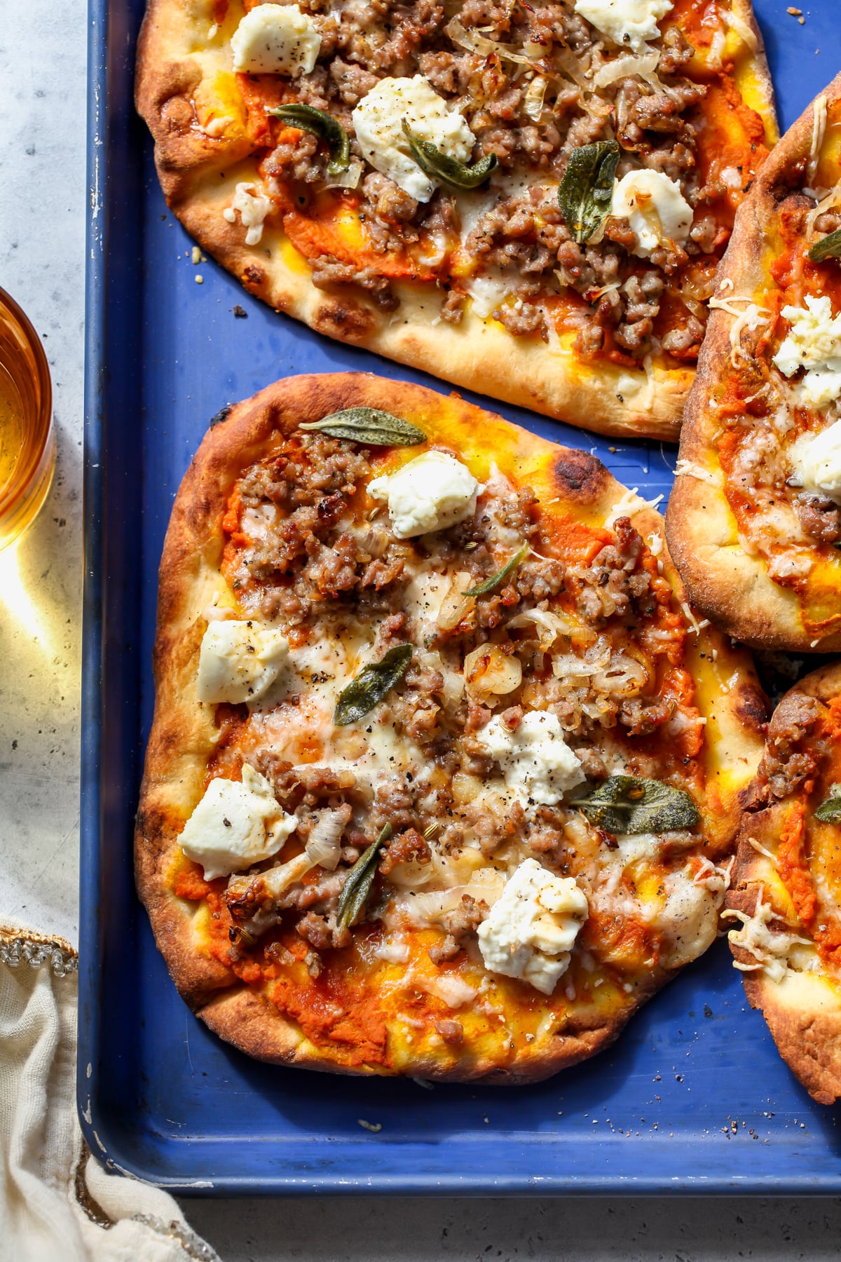 Autumn pizza arranged on a blue baking sheet.
