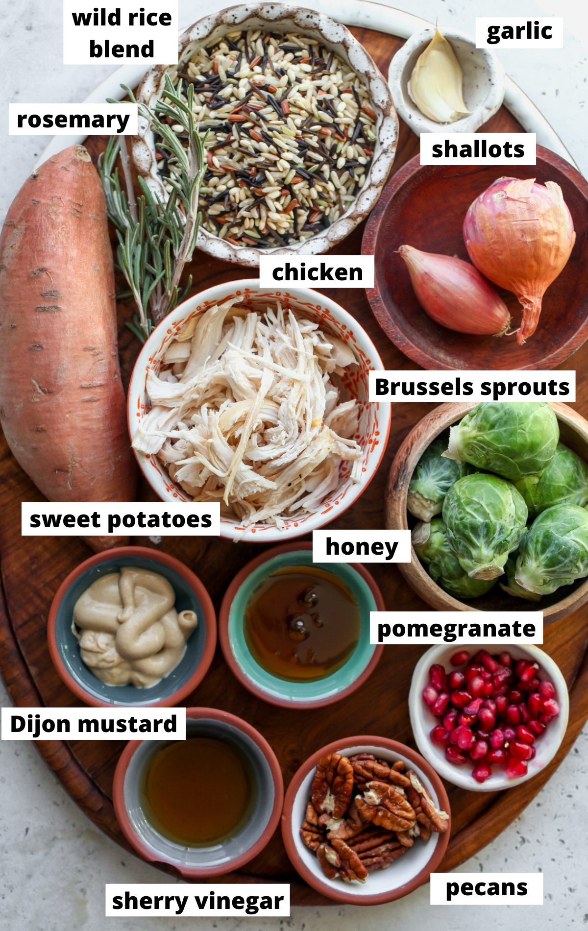 Recipe ingredients arranged on a wooden platter in small bowls with labels.