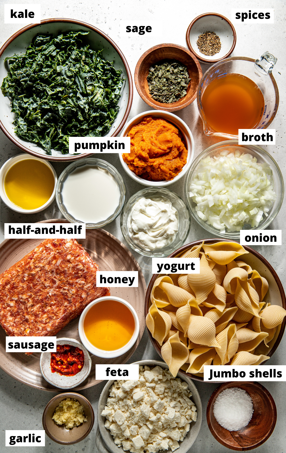 Recipe ingredients in separate bowls assembled on a white surface with labels.