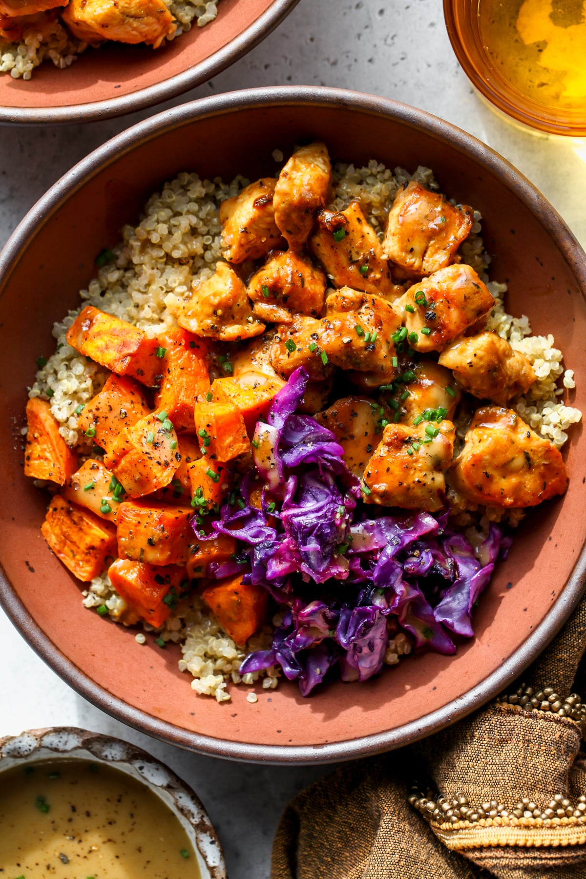 Hot honey mustard chicken bowl styled in a maroon bowl.