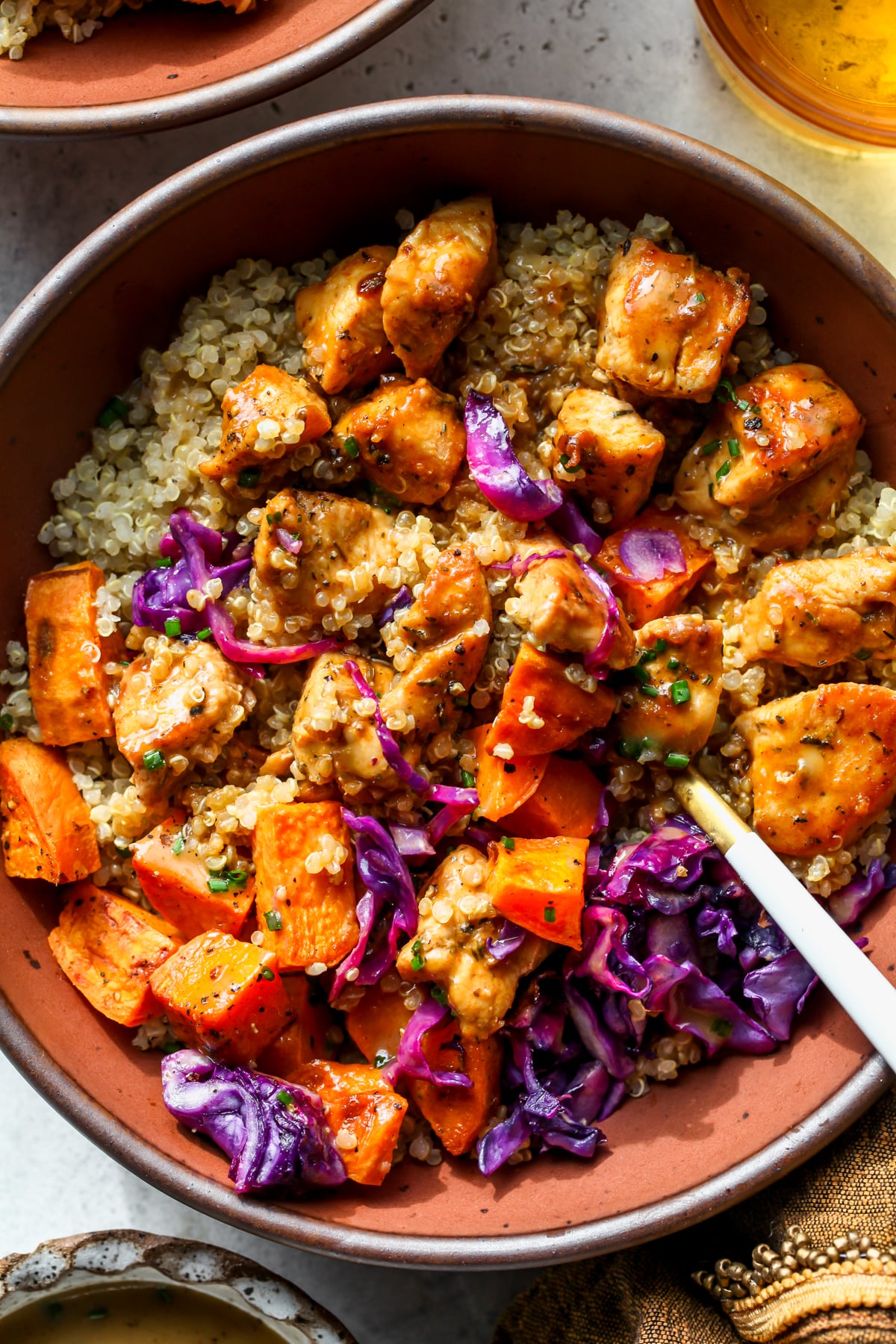 A fork digging into an assembled hot honey mustard chicken bowl.
